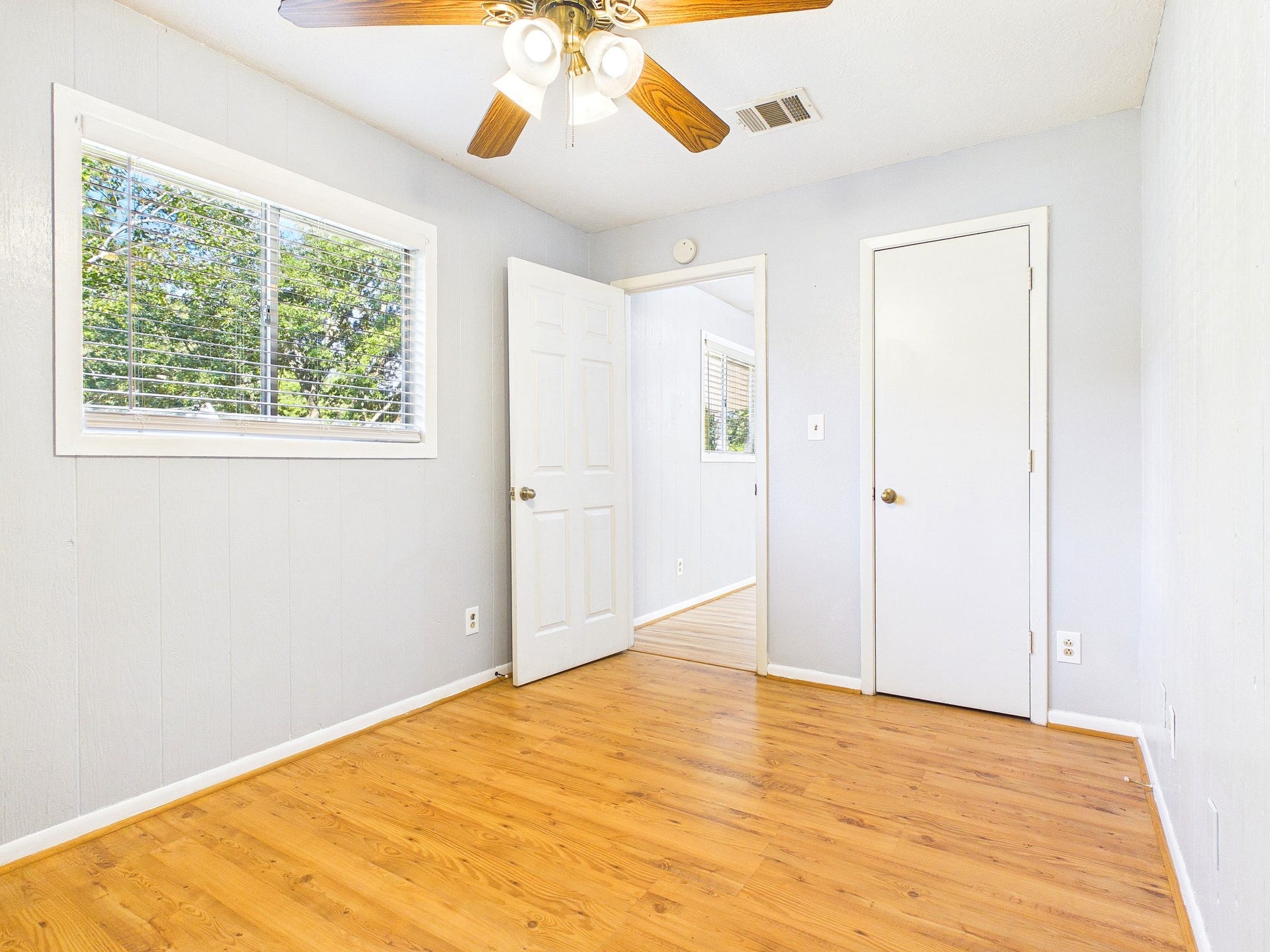 22054 Spears Road, Porter, TX 77365 Bright bedroom with wood-look floors, a ceiling fan, and ample natural light from a large window.