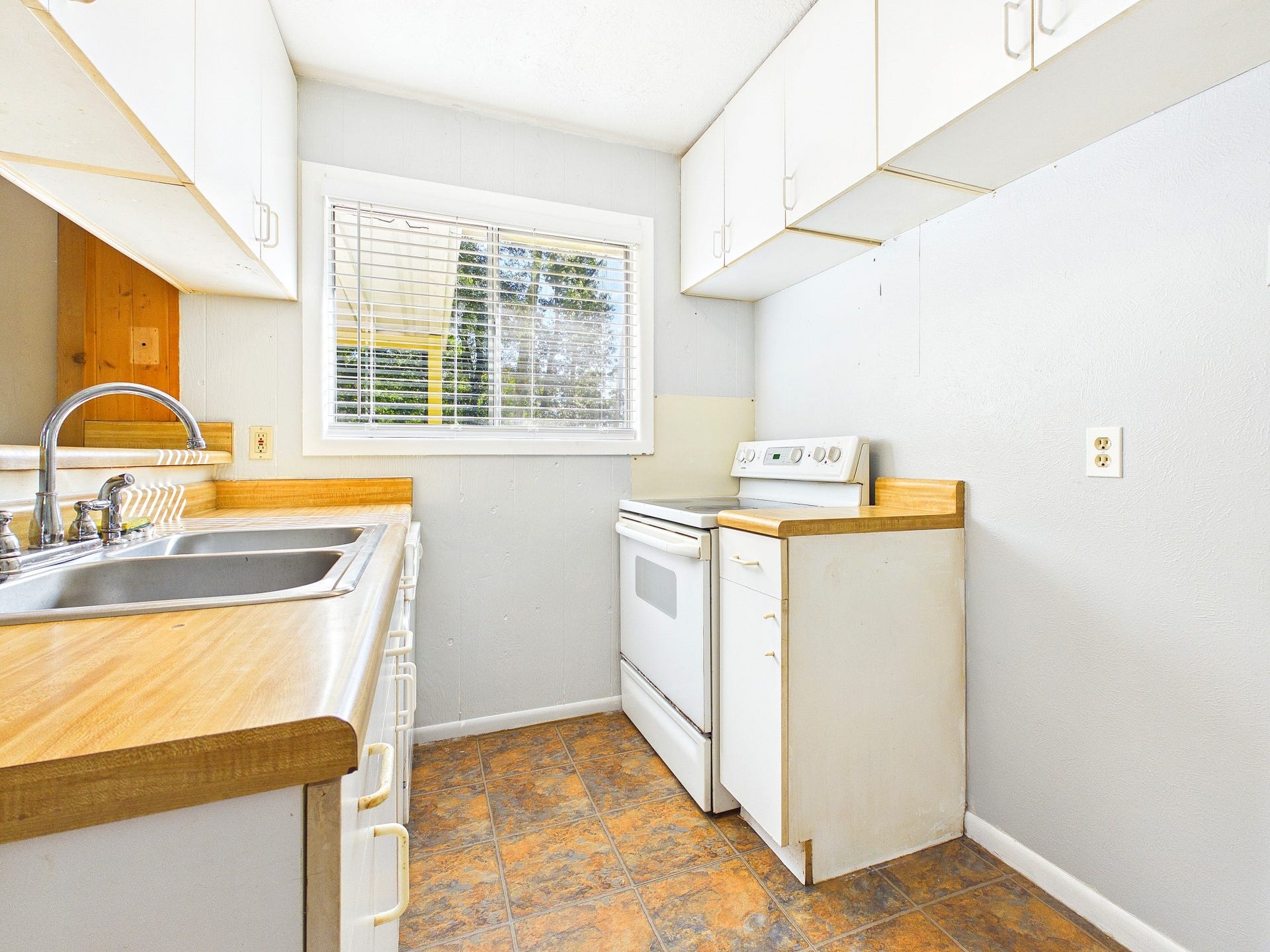22054 Spears Road, Porter, TX 77365 Cozy kitchen with ample natural light, white cabinets, sleek countertops, and a functional layout.