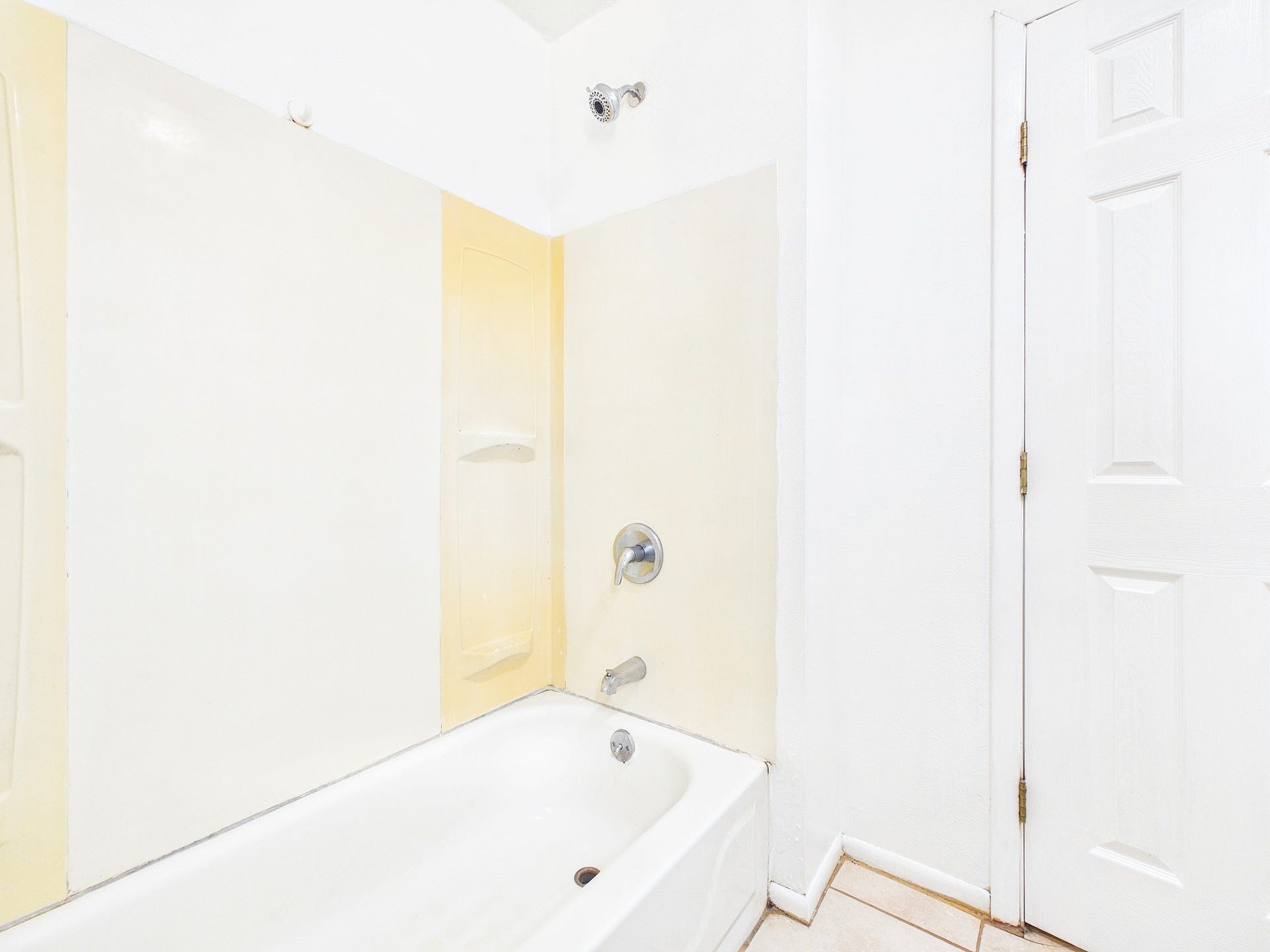 22054 Spears Road, Porter, TX 77365 Bright bathroom featuring a classic white tub with a shower, complemented by neutral tile accents and a clean, minimalistic design.