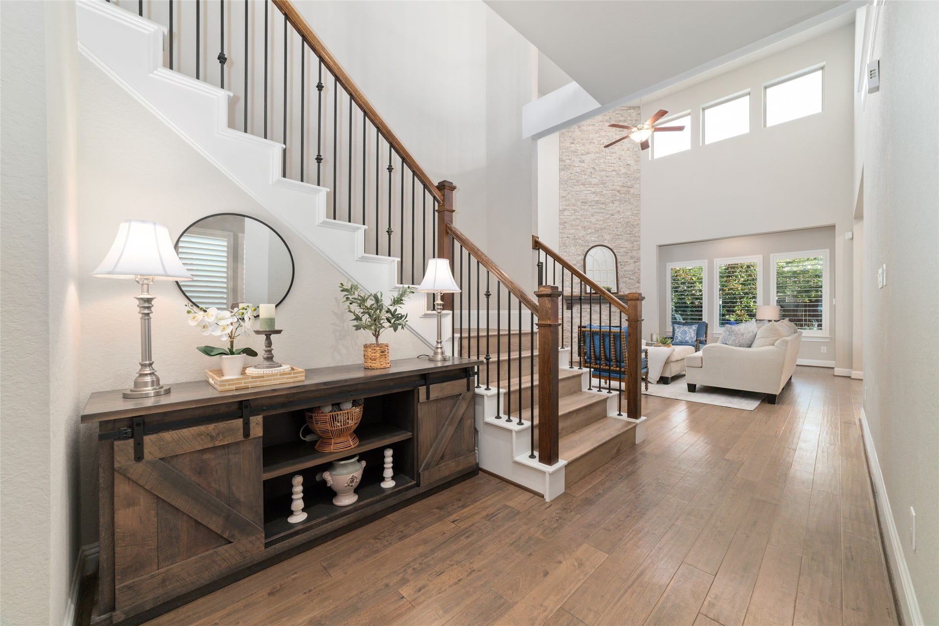 13411 Alpine Mountain Lane, Tomball, TX 77377 Rich hard-surface flooring pairs beautifully with the stunning wood staircase and decorative wrought iron spindles, adding warmth, character, and architectural elegance.