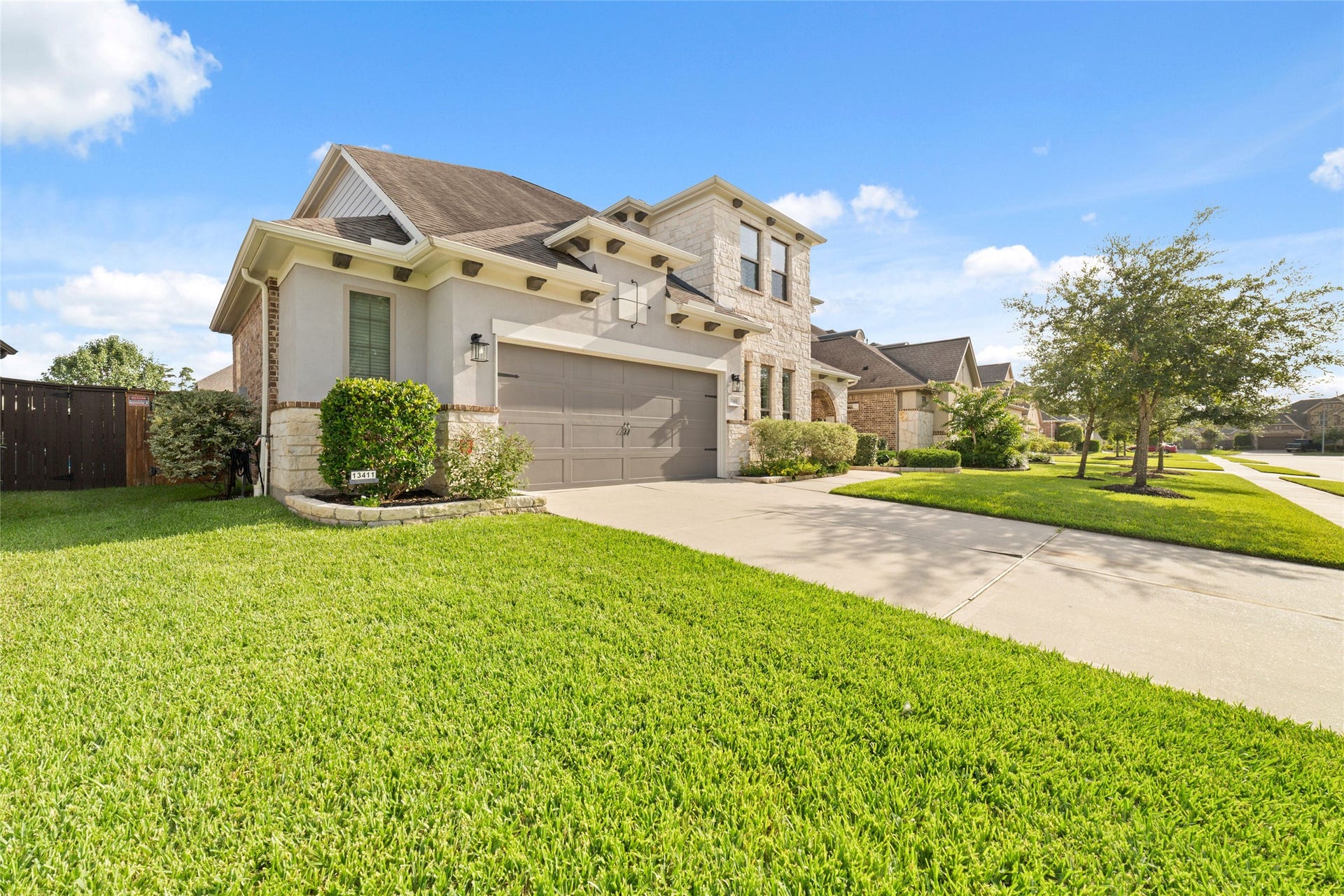 13411 Alpine Mountain Lane, Tomball, TX 77377 Beautiful stucco and stone elevation with mature landscaping and excellent curb appeal create a picturesque front view.