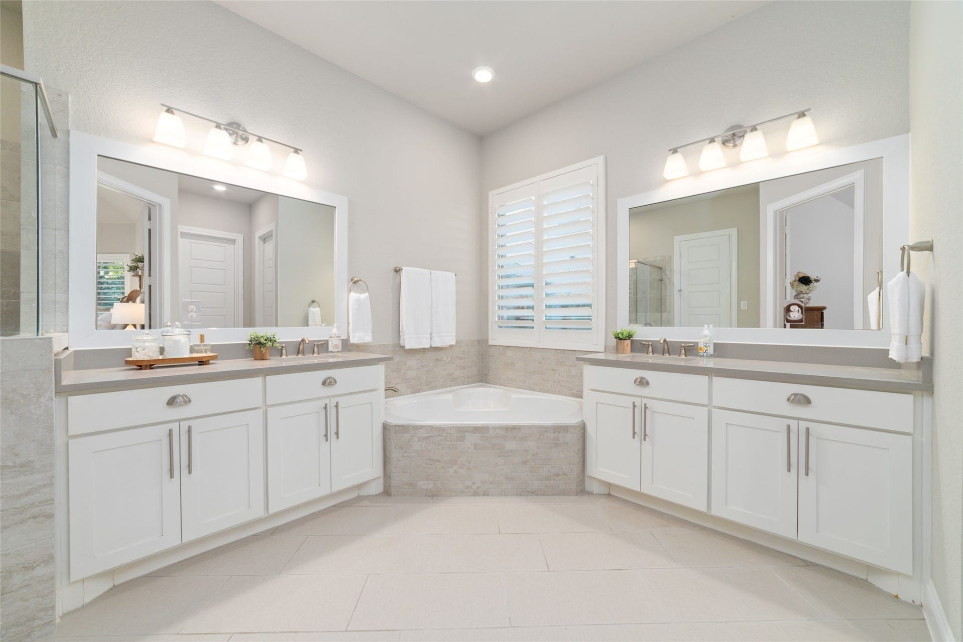 13411 Alpine Mountain Lane, Tomball, TX 77377 Spa-inspired primary bathroom with separate vanities and a spa like soaking tub.