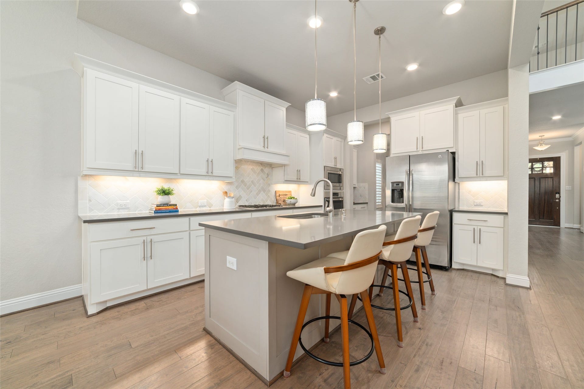 13411 Alpine Mountain Lane, Tomball, TX 77377 Designed for both everyday living and effortless entertaining, the open-concept kitchen features elegant white cabinetry, an oversized island, stainless steel appliances, expansive counter space, ample storage, and a large walk-in pantry.