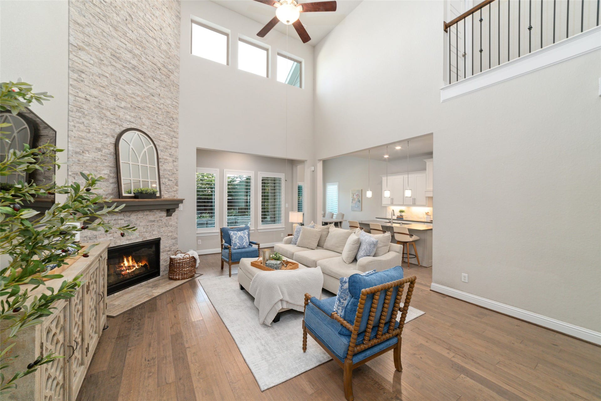 13411 Alpine Mountain Lane, Tomball, TX 77377 The two-story living room is bathed with natural light and anchored by a stunning floor to ceiling, stacked traverstone gas fireplace.