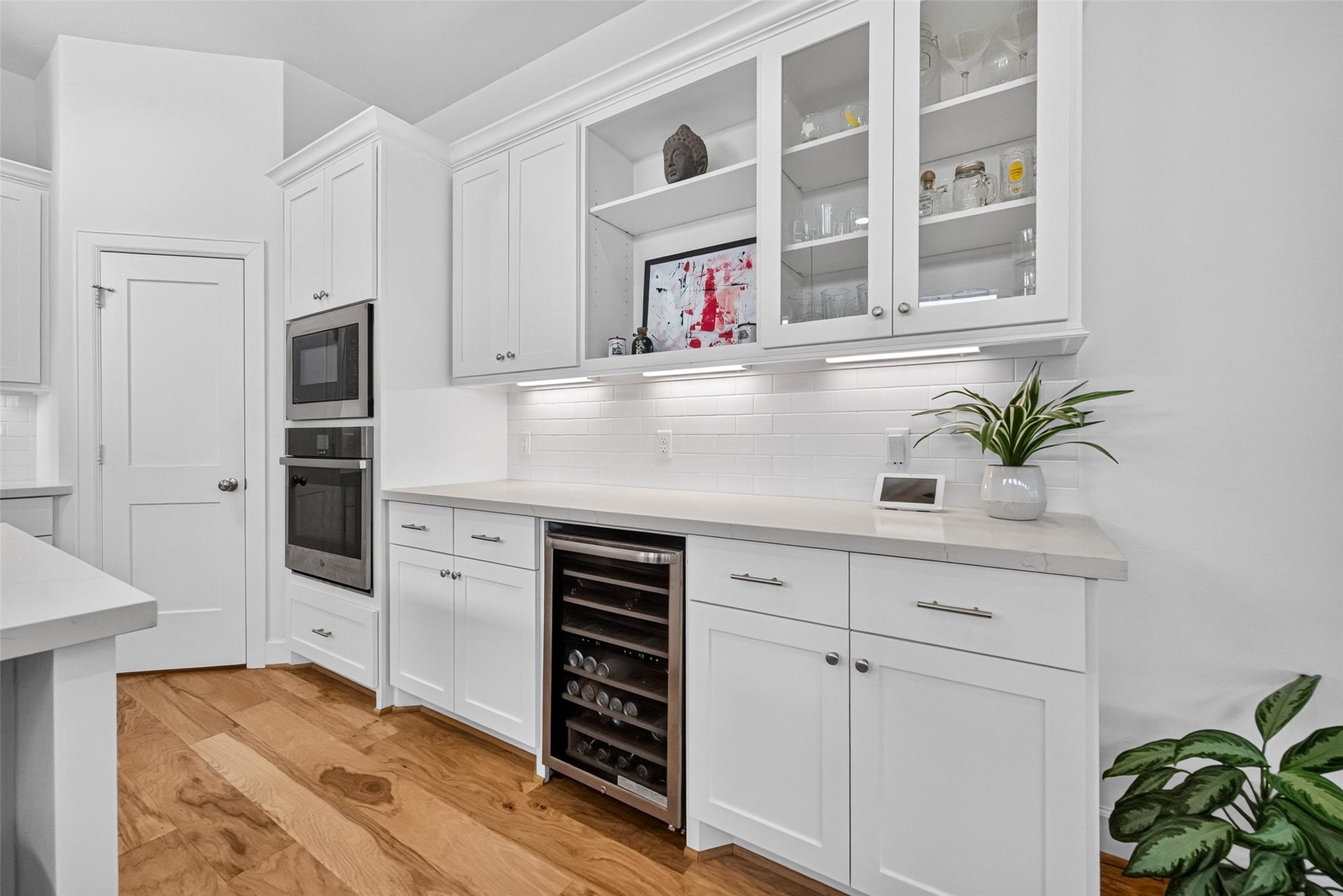 1201 E 23rd Street, Houston, TX 77009 Just to the right of the wall oven and microwave is an area that would be perfect for entertaining with a set of glass front cabinets, open shelving, and a wine/beverage cooler.