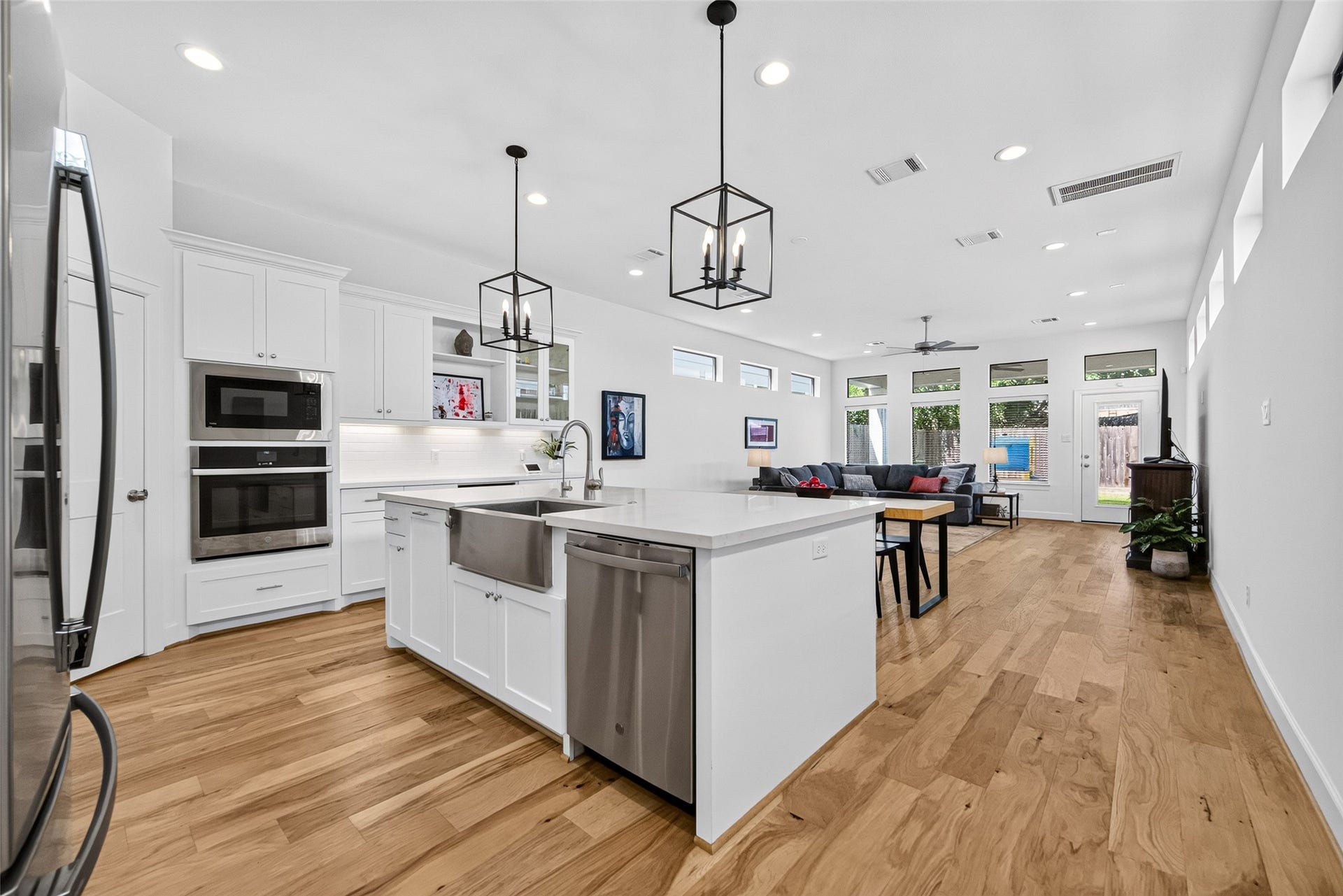 1201 E 23rd Street, Houston, TX 77009 Just of the entry is the gorgeous kitchen with a large island with a farmhouse-style sink, trash and recycling drawer, and dishwasher.