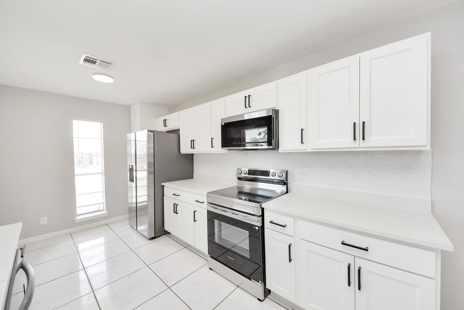 Stove and fridge side of kitchen showing breakfast area