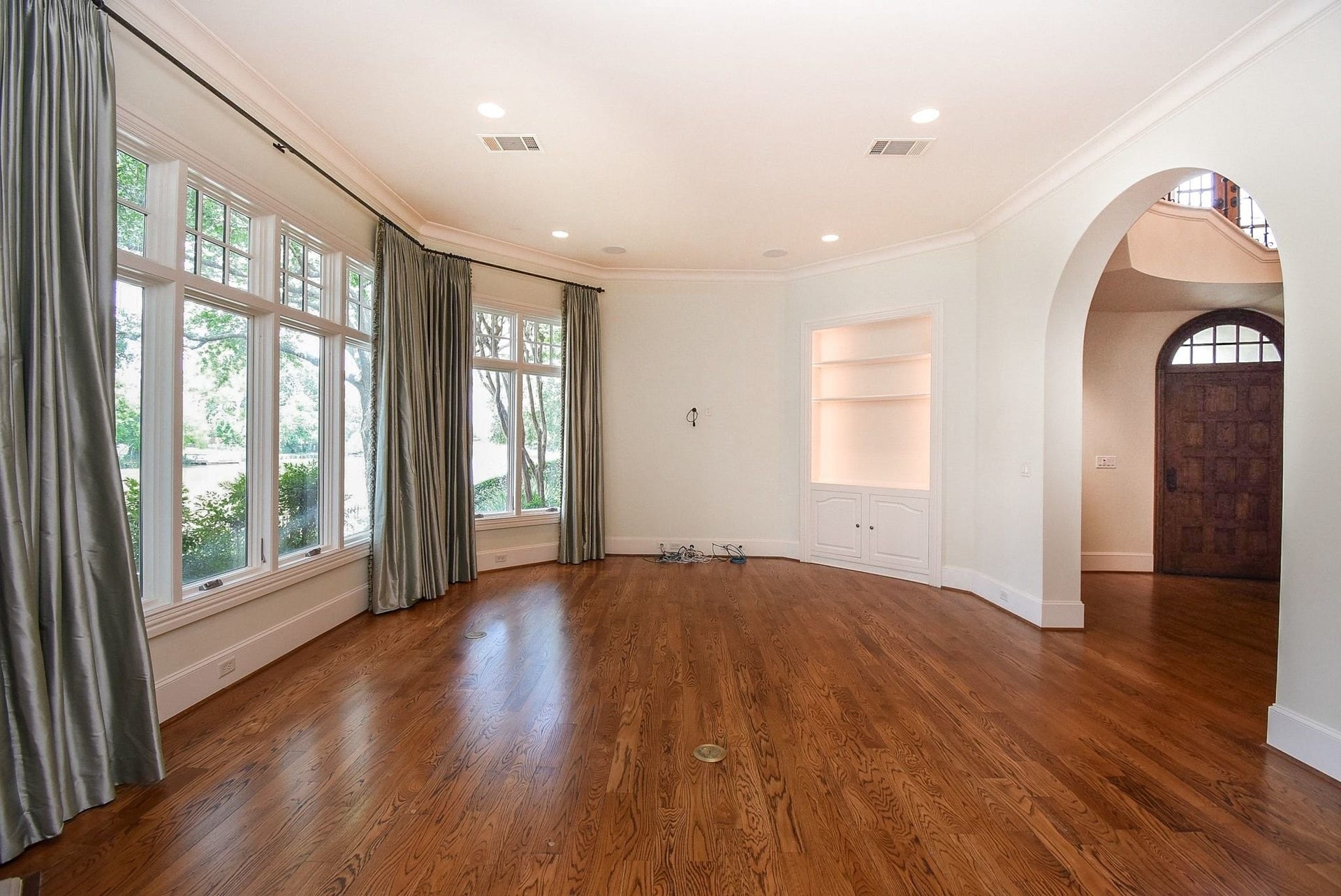 Living room view toward the front entry with built ins and crown molding
