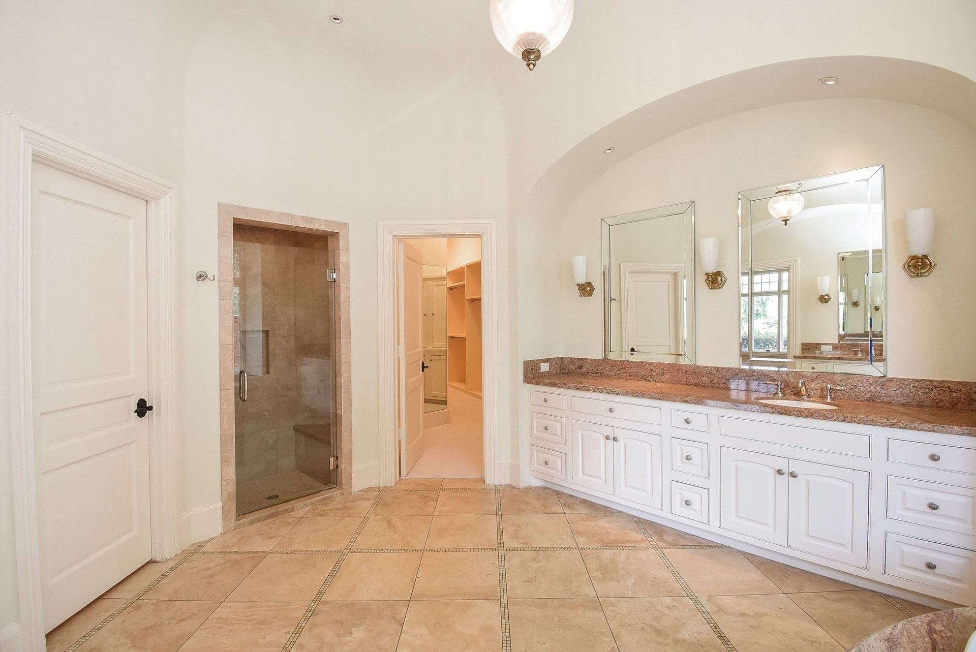 This spacious primary bath has an oversized walk-in closet with great built ins and the laundry room at the other end.