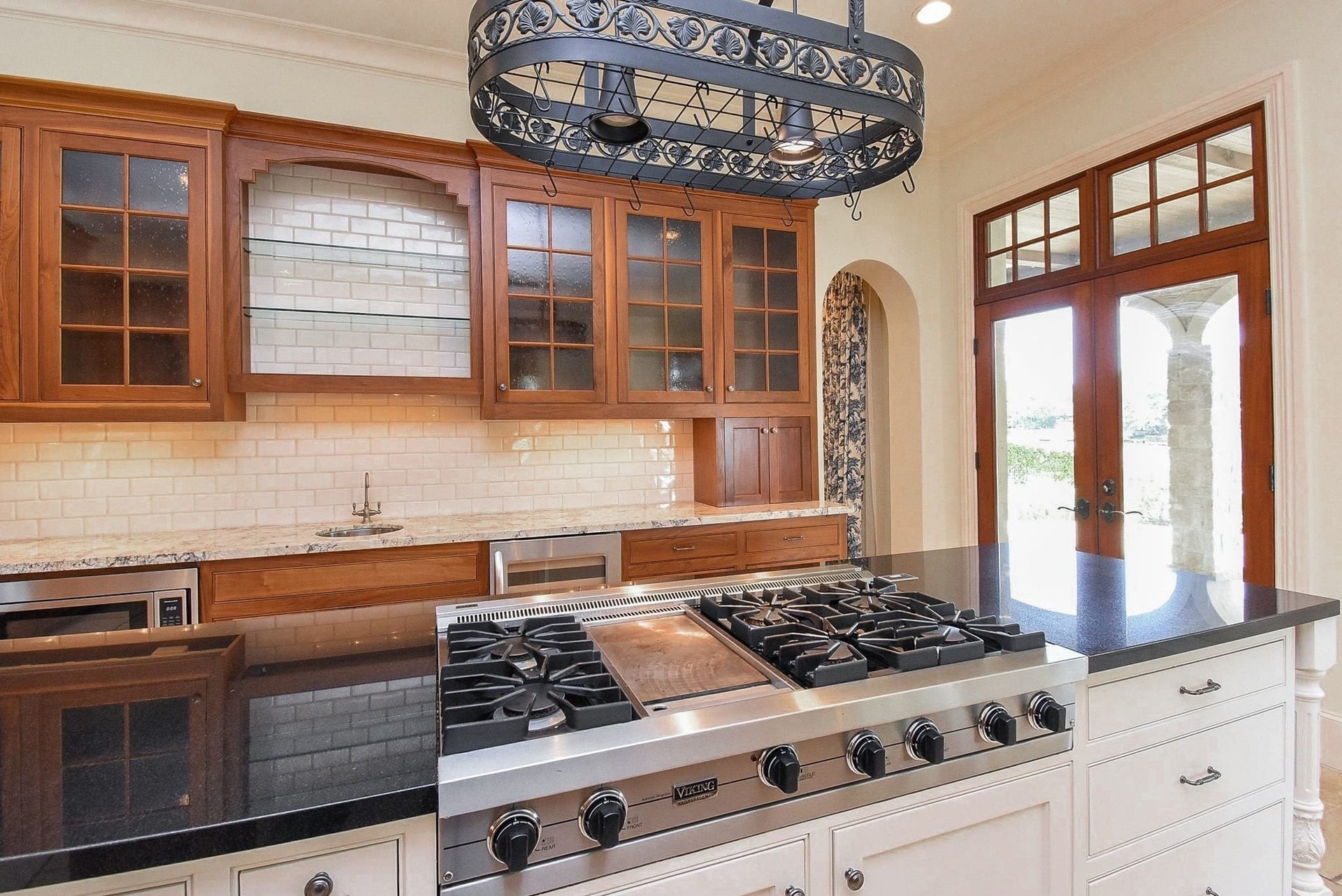 Close up of Viking 6 burner gas cooktop.  Also, notice the vegetable sink and wine fridge on the back counter