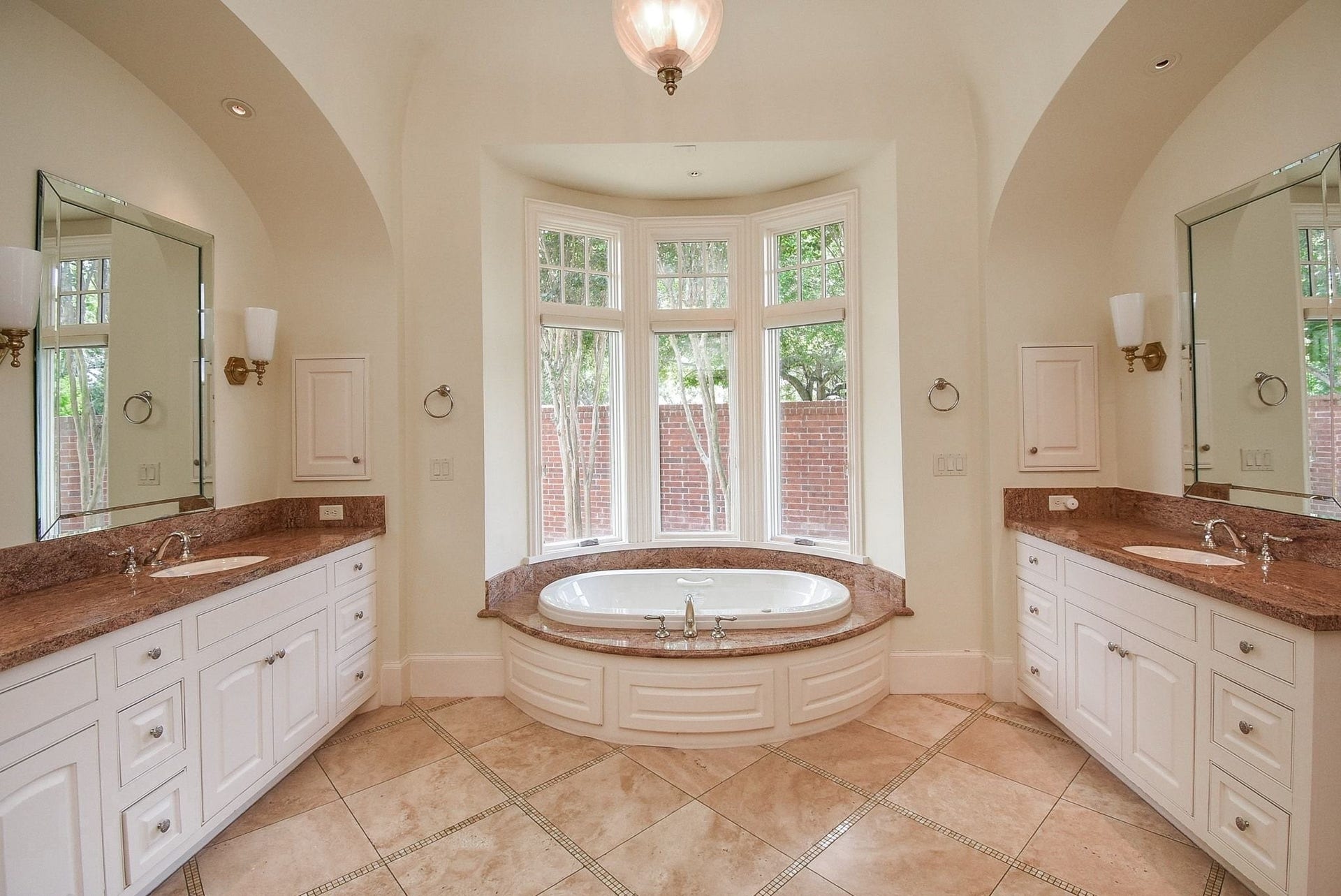 Primary bath with not only double sinks, but separate vanities.  No one messing up my vanity, sign me up!
Soaker tub with peaceful garden view and great natural light in here.   The windows all have shades for darkening and privacy