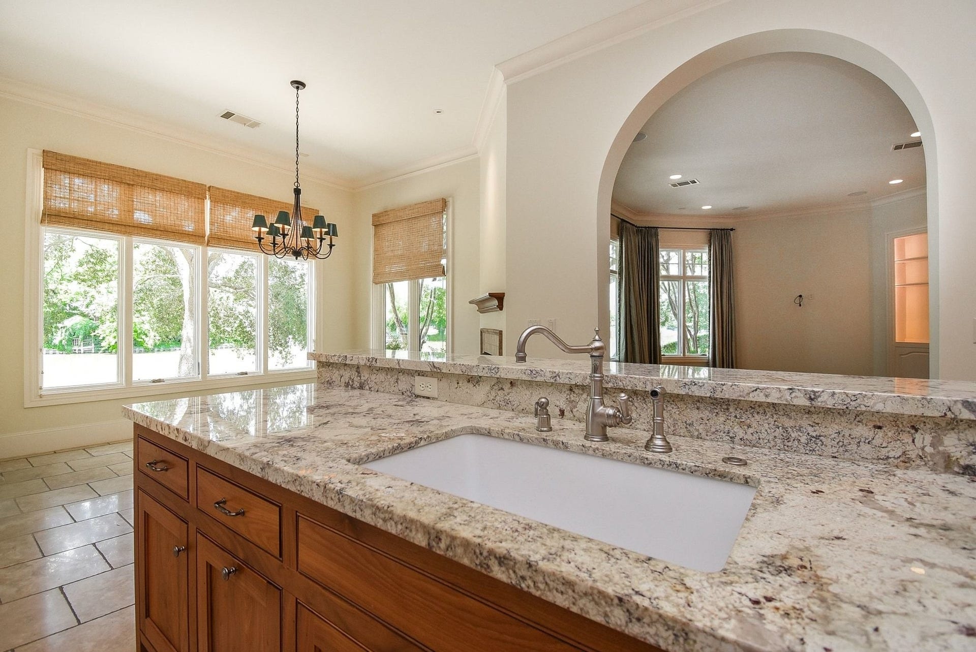 Large farmhouse style sink and close up of the gorgeous granite with peek into the breakfast area.  This home has a water softener and a reverse osmosis (RO) filter system