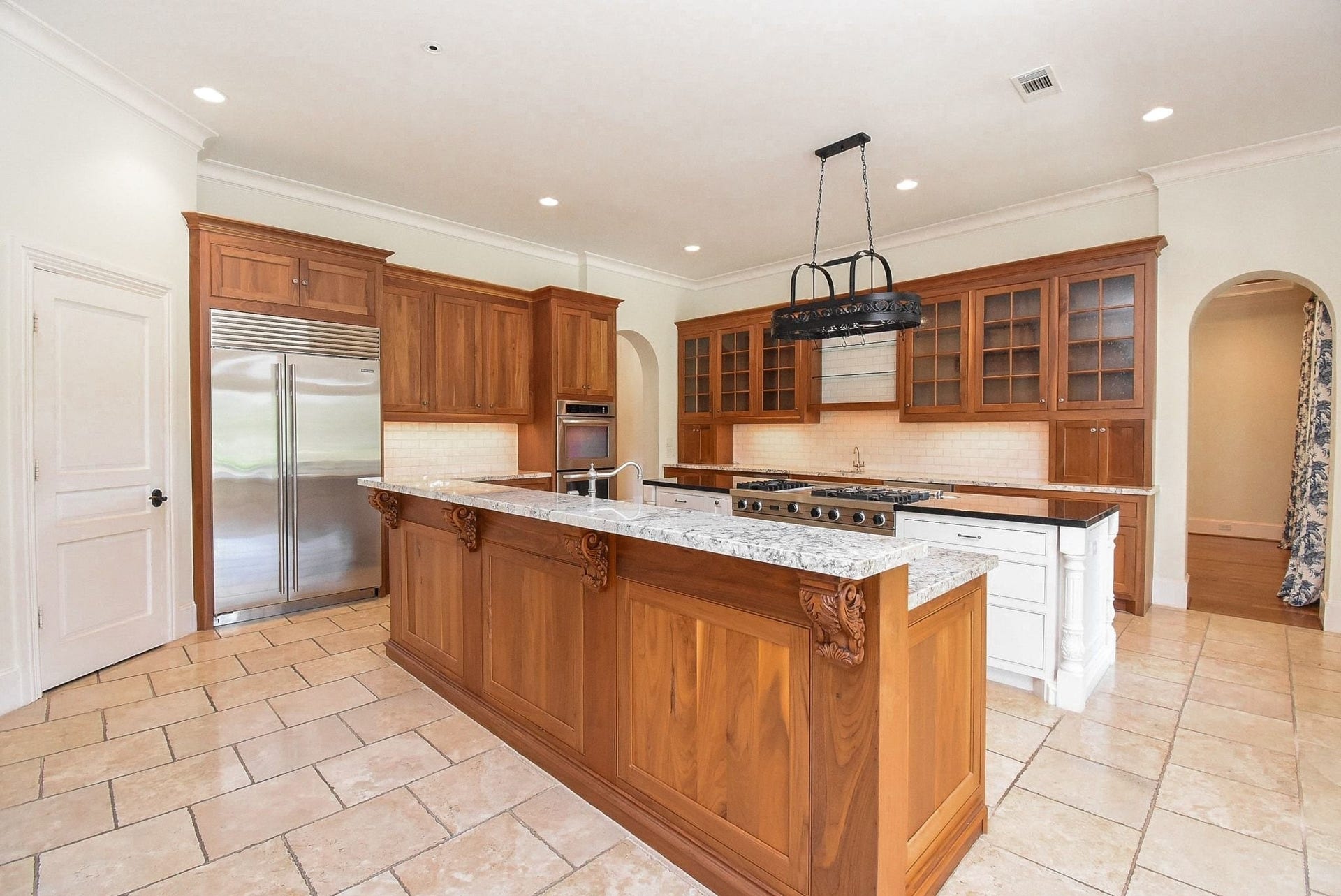 This kitchen, WOW!  Double island with high level granite and travertine flooring.  Sub Zero refrigerator and double ovens of course!