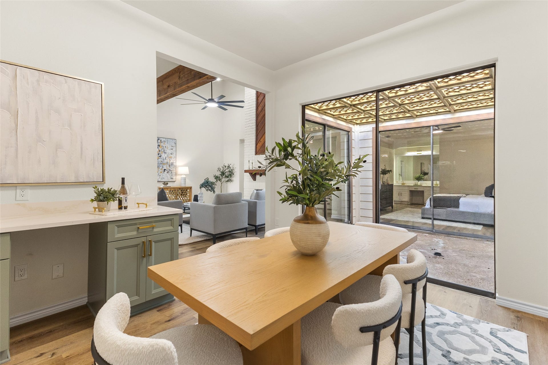 Your inviting dining area showcases warm wood-look flooring, a convenient built-in serving counter with cabinetry, and expansive sliding glass doors offering views of the private courtyard and easy access to the living room.