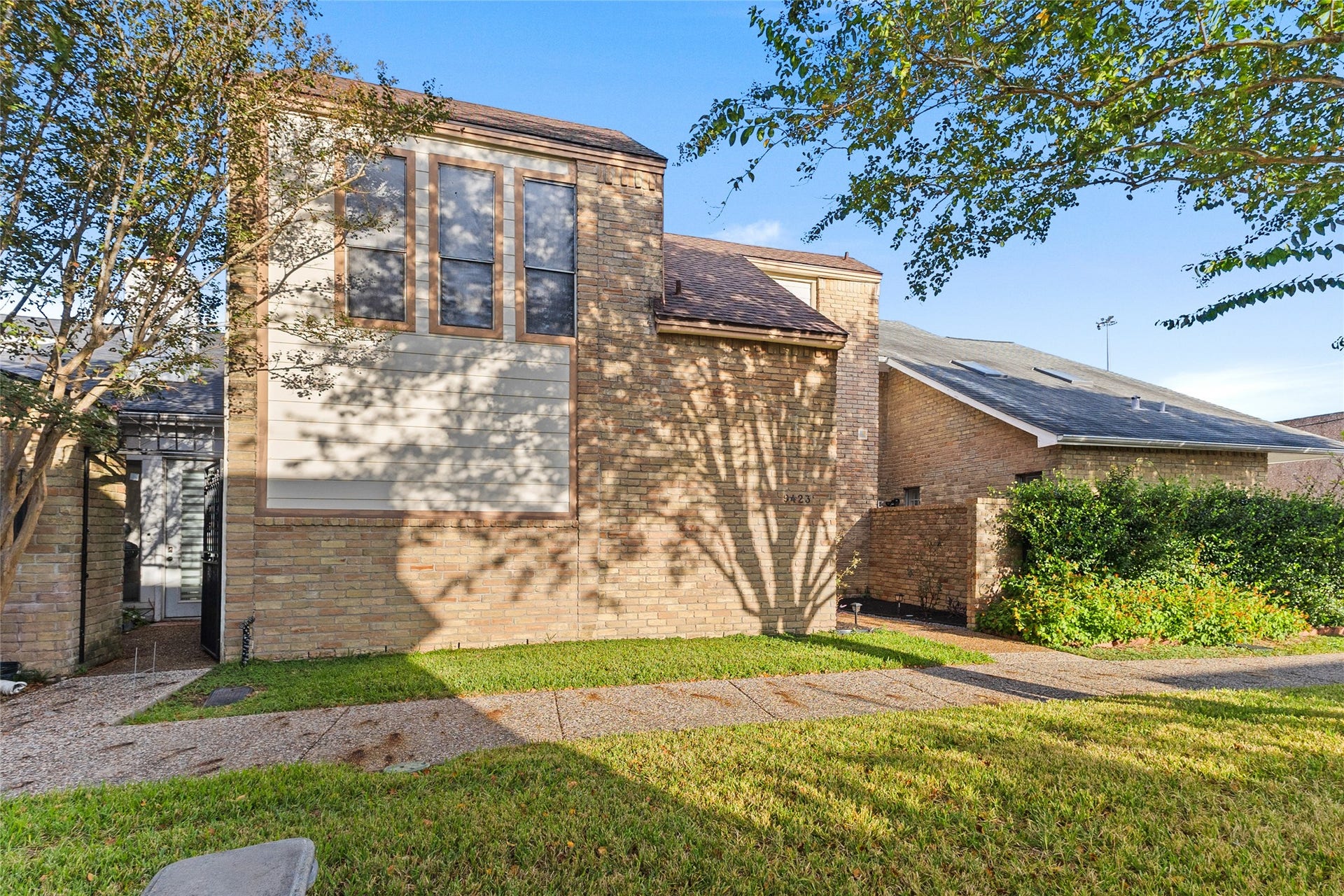 Welcome to 9423 Denbury. This newly renovated brick townhome offers great curb appeal, shaded by mature trees, with a landscaped entry, a pebble walkway lined with path lights, and lush greenery that adds privacy and color.