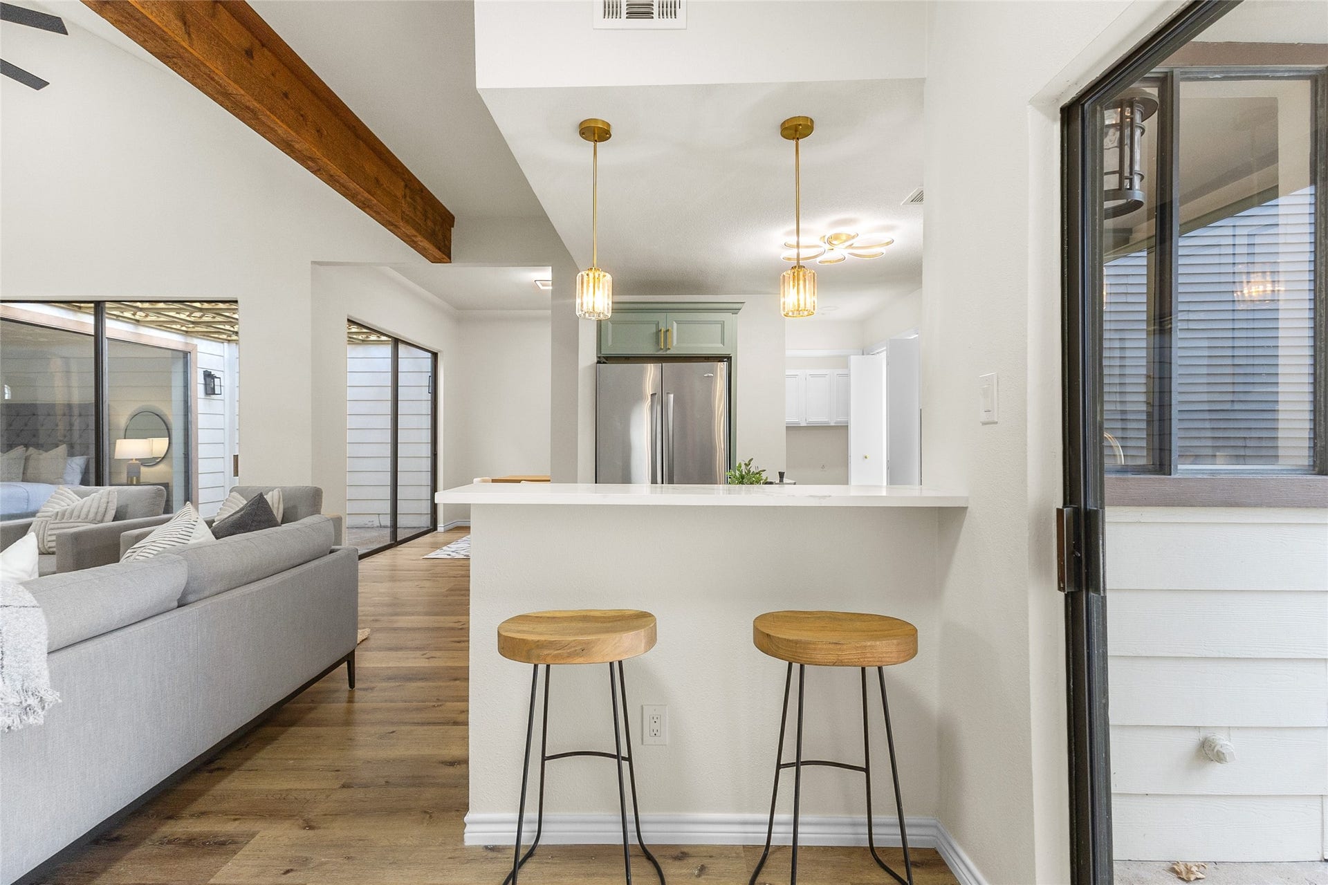 Your breakfast bar offers convenient seating for two, elegant pendant lighting, and a sleek countertop, creating a welcoming space for casual dining and entertaining.