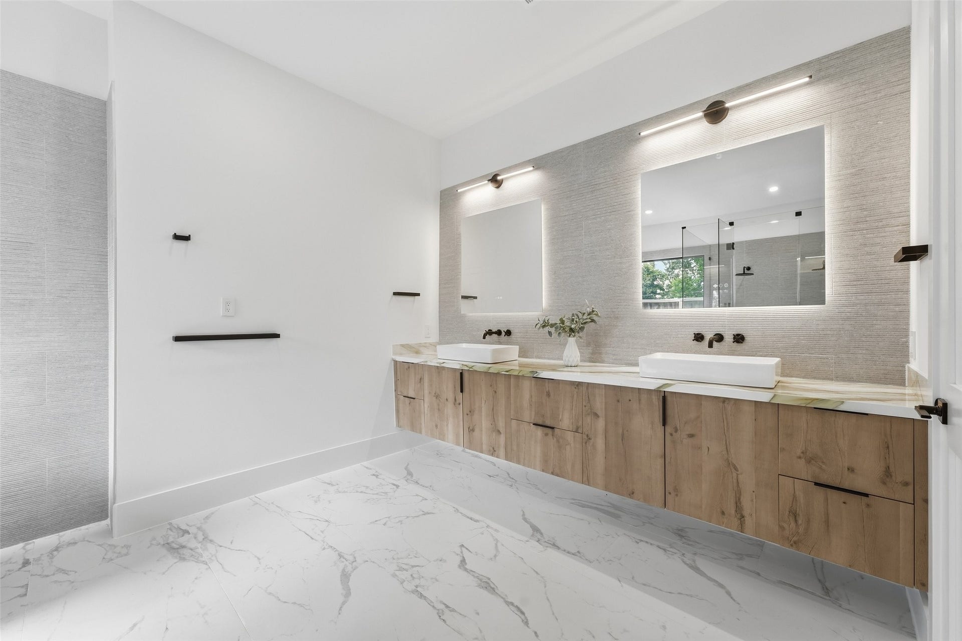 519 W 30th Street, Houston, TX 77018 A spa-inspired primary bath with a freestanding soaking tub, floating dual vanity, oversized mirrors, and a spacious glass-enclosed shower.