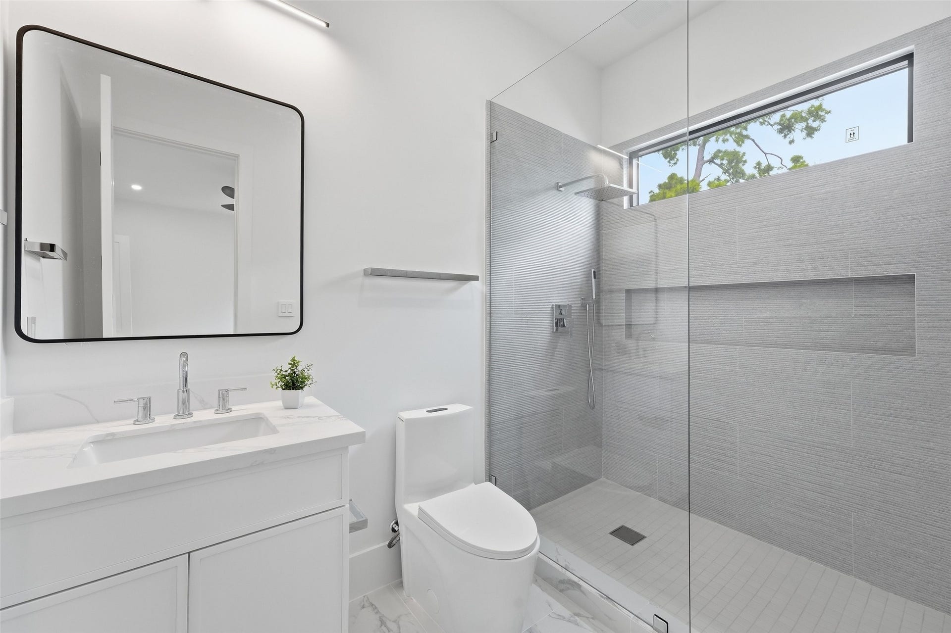 519 W 30th Street, Houston, TX 77018 Luxurious ensuite bath with a spacious layout, shower ledge, and abundant natural light.