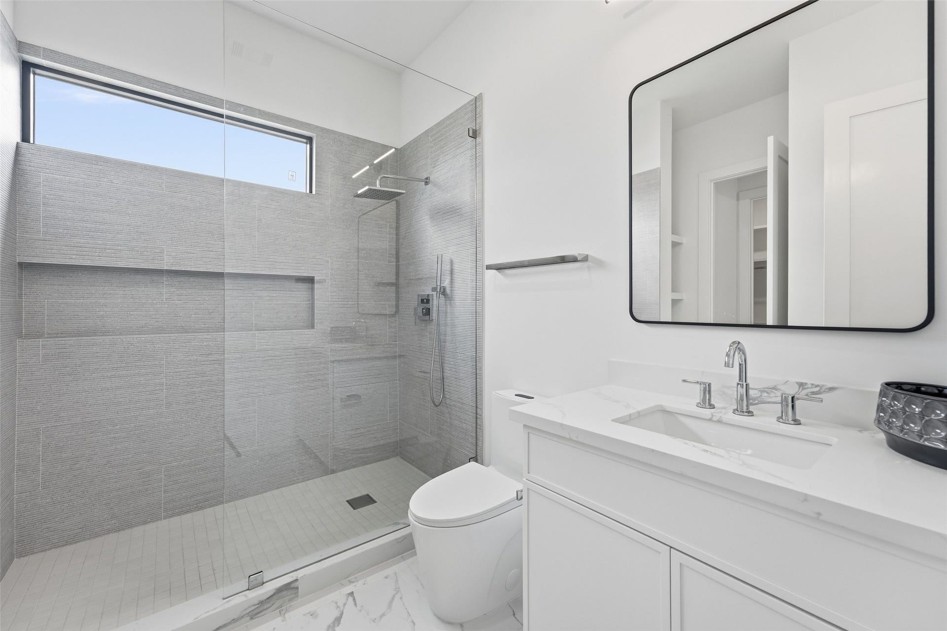 519 W 30th Street, Houston, TX 77018 Luxurious ensuite bath featuring a sleek glass shower, elegant vanity, and modern fixtures.