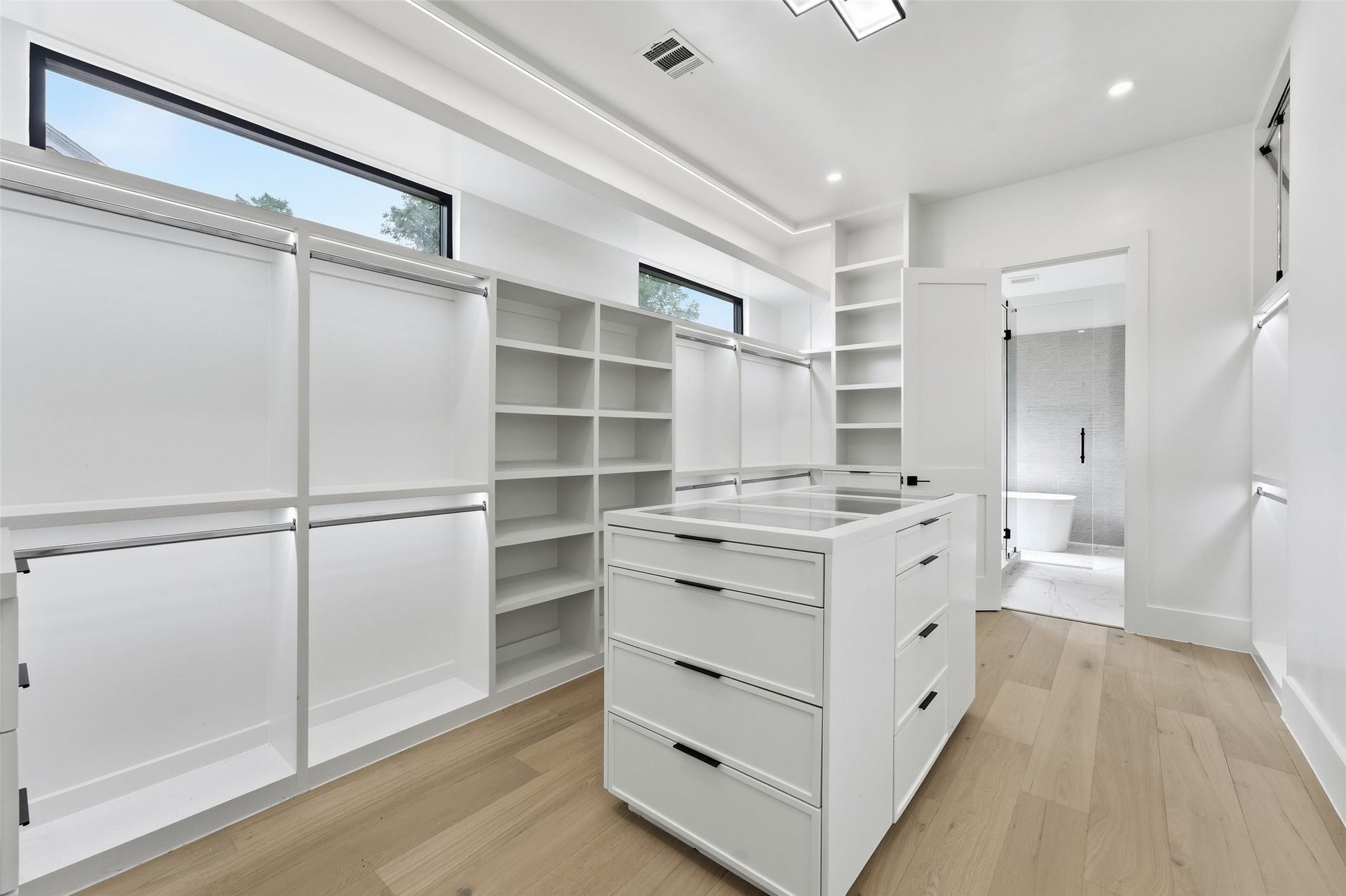 519 W 30th Street, Houston, TX 77018 An expansive custom walk-in closet with abundant hanging space, built-in drawers, open shelving, and a central storage island for effortless organization.