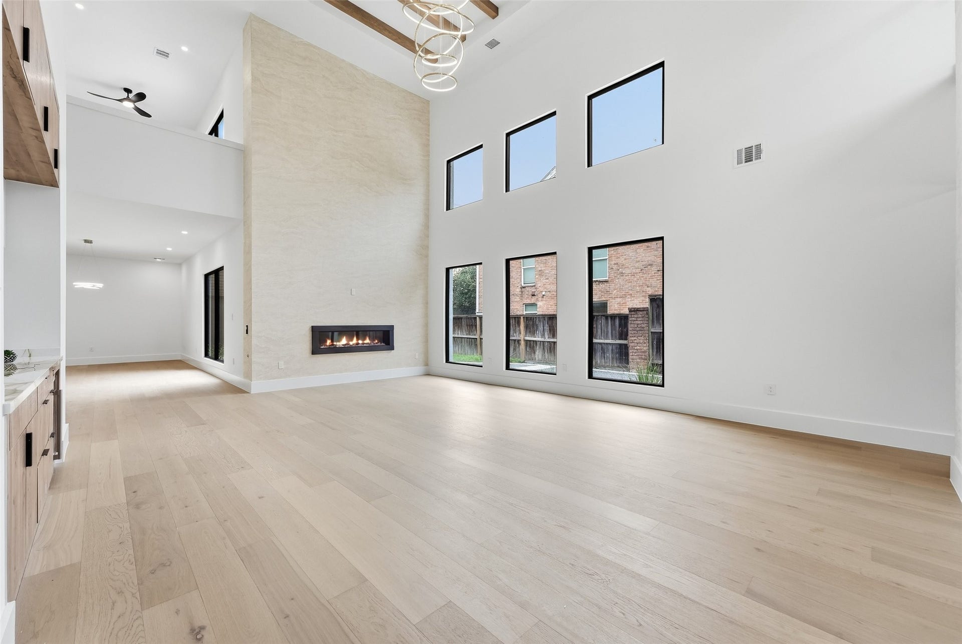 519 W 30th Street, Houston, TX 77018 Expansive wall of windows and a cozy fireplace create an inviting atmosphere, perfect for showcasing art.
