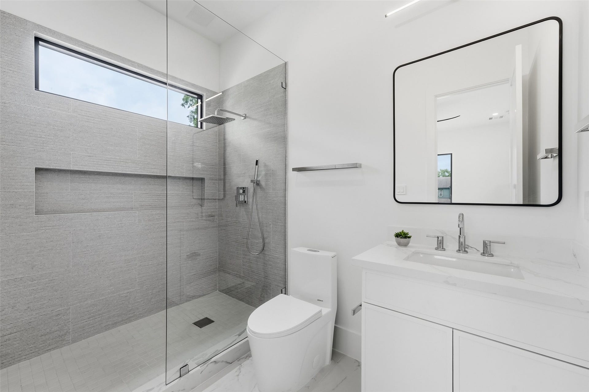 519 W 30th Street, Houston, TX 77018 Luxurious ensuite bath with elegant finishes and a sleek design.