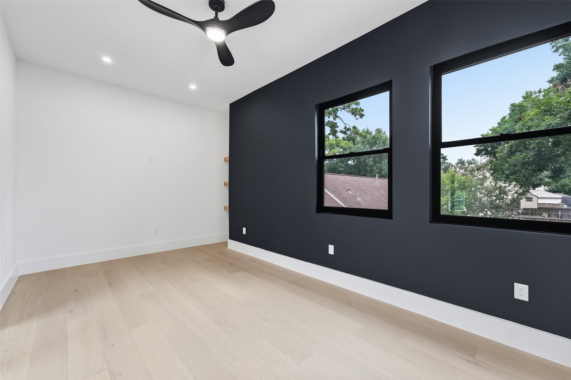 519 W 30th Street, Houston, TX 77018 Inside a dramatic charcoal accent wall and oversized windows frame elevated treetop views while filling the room with natural light.