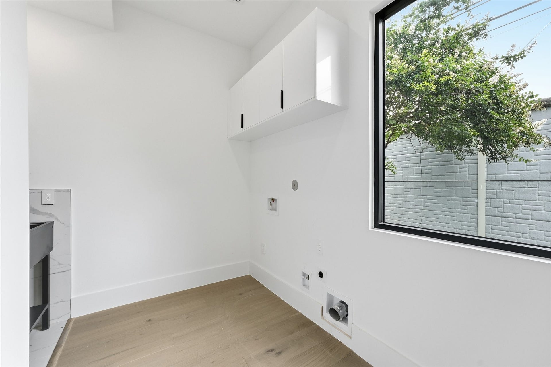 519 W 30th Street, Houston, TX 77018 A bright, well-appointed utility room with abundant natural light, overhead cabinetry, and dedicated space for a full-size front or top loading washer and dryer.