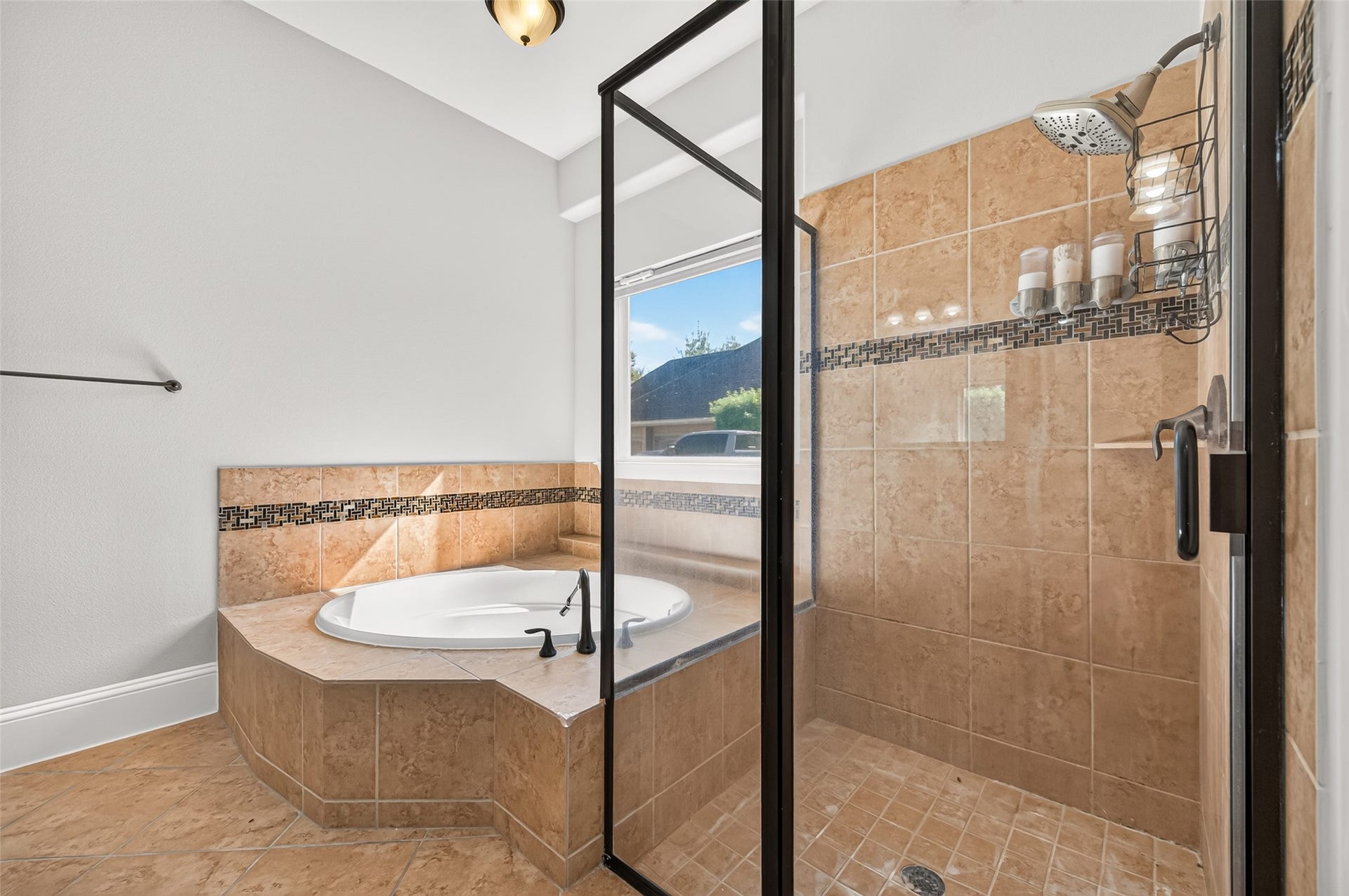 5119 Water Oak Crescent, Fulshear, TX 77441 Spa-like primary bath! Indulge in the deep corner soaking tub with elegant tile detailing. Features a massive granite-topped vanity with dual sinks, rich wood cabinetry, a large framed mirror, stylish lighting, and a massive walk-in layout.
