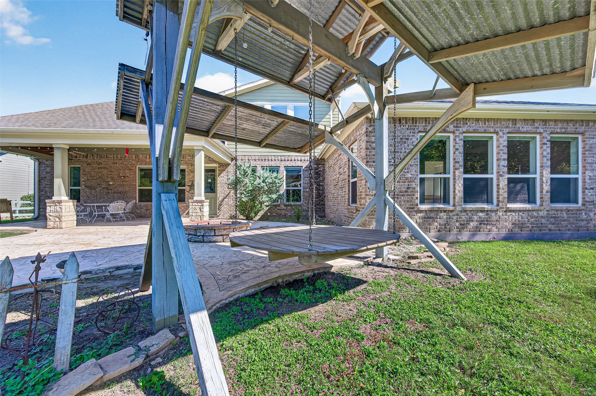 5119 Water Oak Crescent, Fulshear, TX 77441 backyard oasis! Massive covered patio with stone pillars, stamped concrete extension, built-in fire pit, and plenty of green space to entertain.