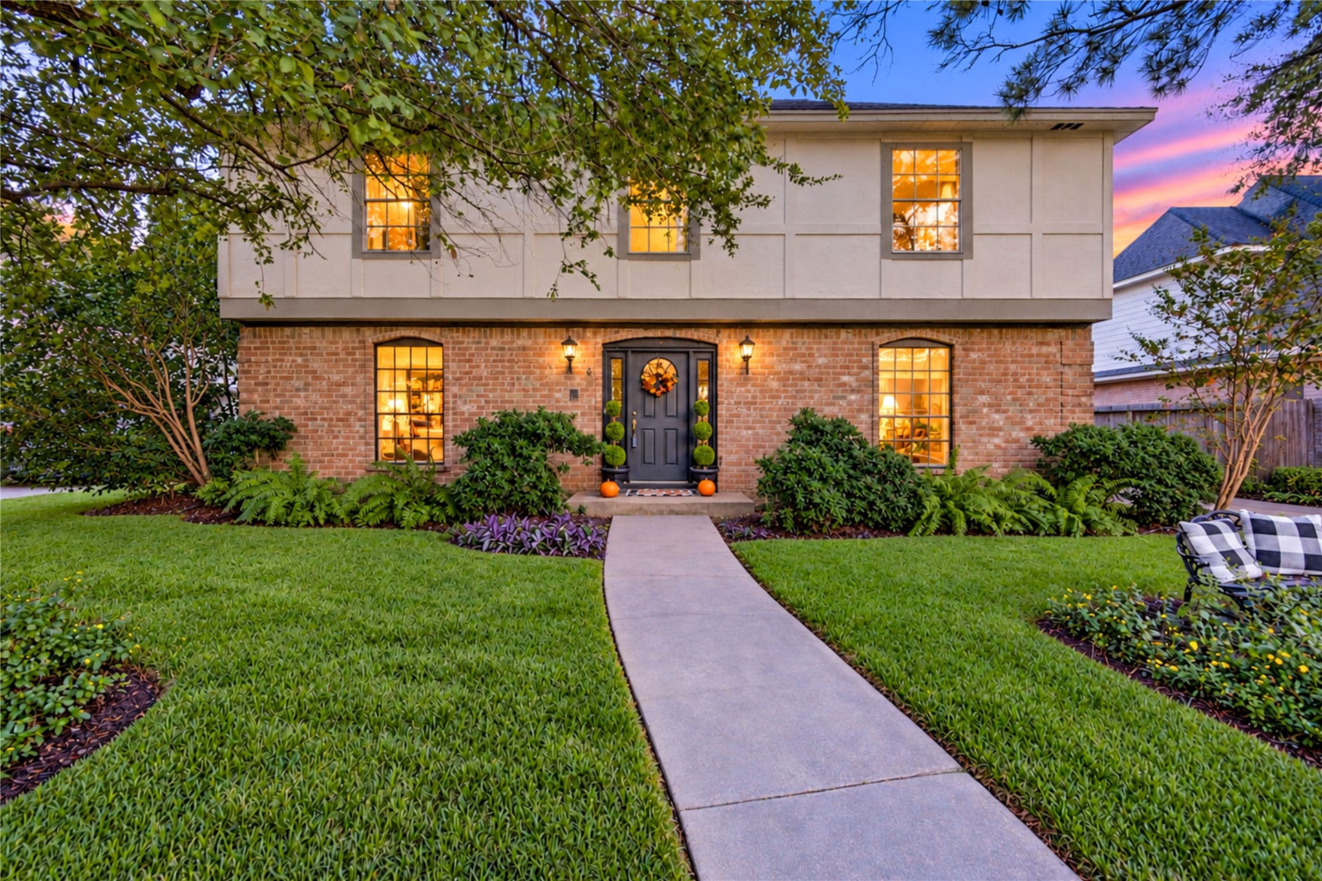 11423 Inwood Drive, Houston, TX 77077 A warm welcome awaits as the sun begins to set! This beautiful two-story home shines with timeless brick architecture, lush landscaping and mature shade trees. The softly illuminated front entry and inviting walkway create a picture-perfect setting, while the peaceful evening glow adds a touch of magic. Imagine returning home after a busy day to this charming retreat in the heart of Village West, where classic curb appeal meets everyday comfort!