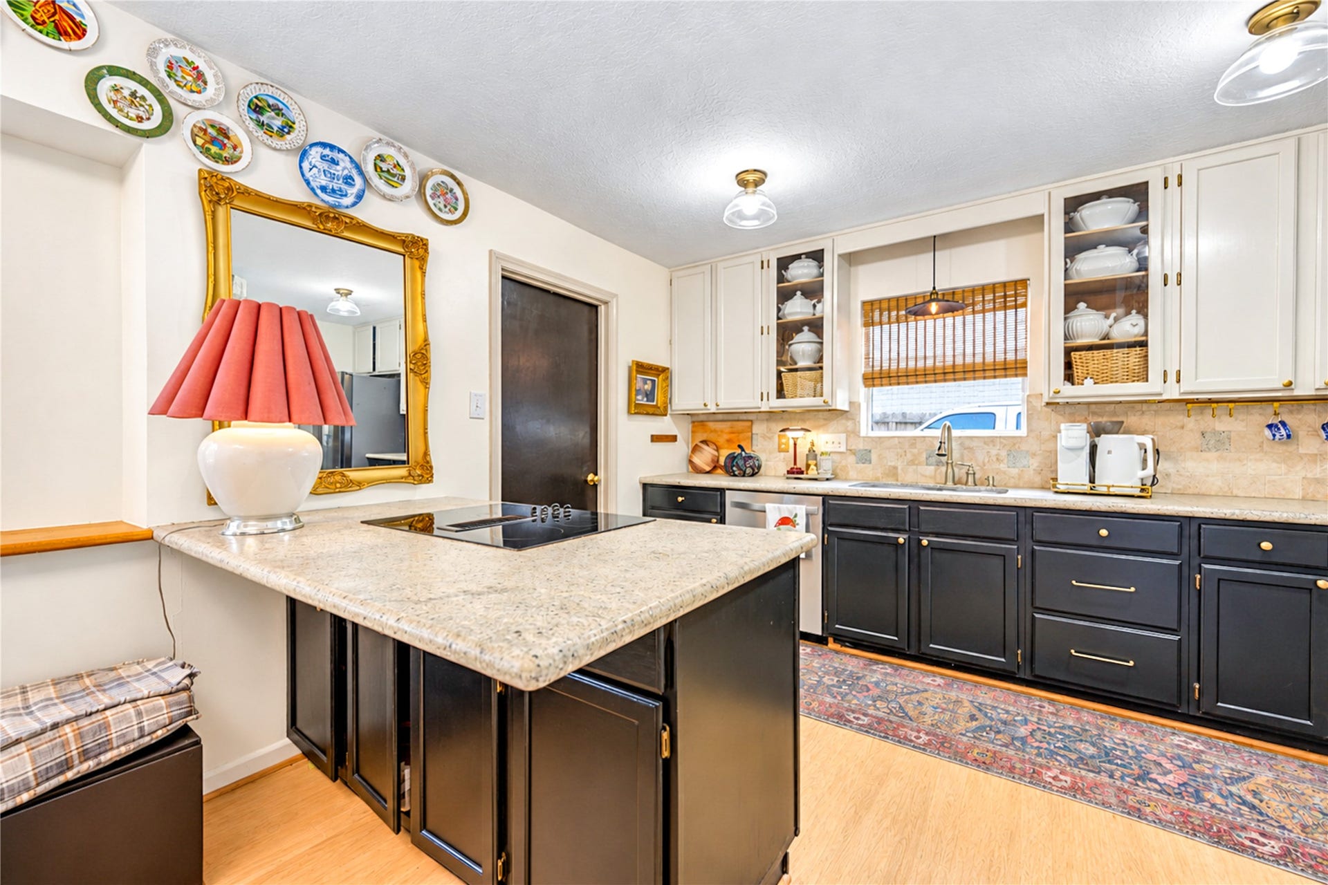 11423 Inwood Drive, Houston, TX 77077 The perfect gathering spot! This inviting kitchen features a spacious granite-topped breakfast bar with a convenient cooktop, rich contrasting cabinetry and a beautiful travertine backsplash. Whether preparing a favorite meal, enjoying casual conversation over coffee or entertaining friends, this thoughtfully designed space brings warmth, character and everyday functionality to the heart of the home!