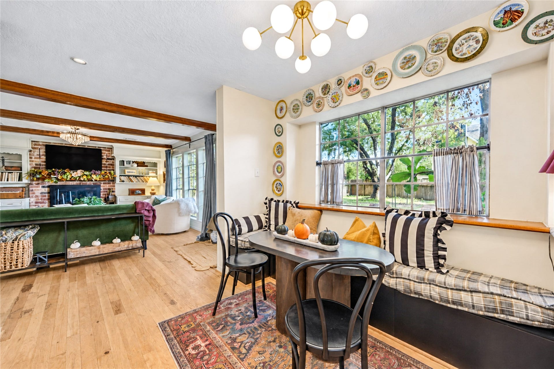 11423 Inwood Drive, Houston, TX 77077 Start your mornings with sunshine and a cozy spot to linger! This charming breakfast room features a delightful built-in window seat overlooking the greenery outside, beautiful wood floors and a stylish statement chandelier. Thoughtful designer touches create a warm, inviting space perfect for sipping morning coffee, enjoying casual meals or curling up by the window with a favorite book. A little everyday luxury!