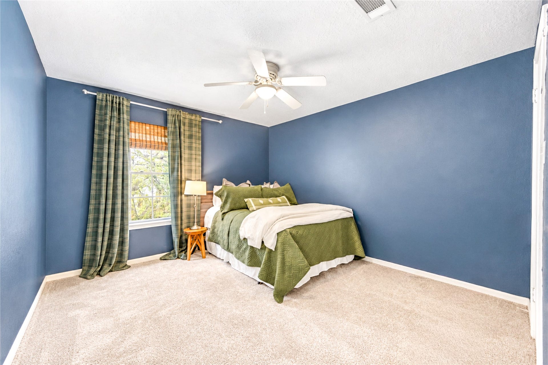 11423 Inwood Drive, Houston, TX 77077 A peaceful retreat with room to make it your own! This inviting third bedroom features rich blue walls, soft carpeting, a ceiling fan and natural light that creates a relaxing atmosphere. Whether used as a welcoming guest room, creative space or personal sanctuary, this versatile bedroom offers comfort, charm and endless possibilities to suit your lifestyle!