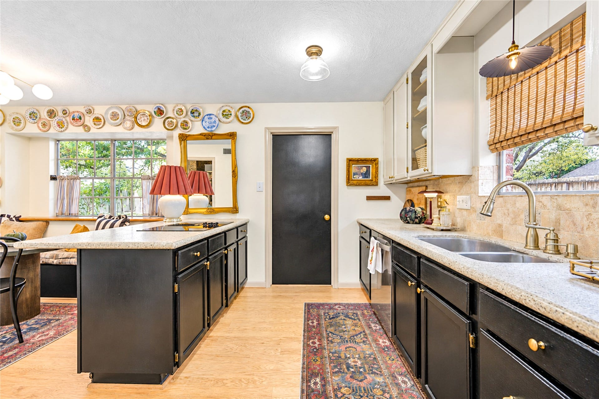 11423 Inwood Drive, Houston, TX 77077 The heart of the home! This beautifully appointed kitchen blends timeless charm with everyday functionality, featuring rich cabinetry, granite countertops, a travertine backsplash and a spacious center island. Sunlight fills the space, creating the perfect setting for morning coffee, preparing favorite recipes or gathering with friends and family.