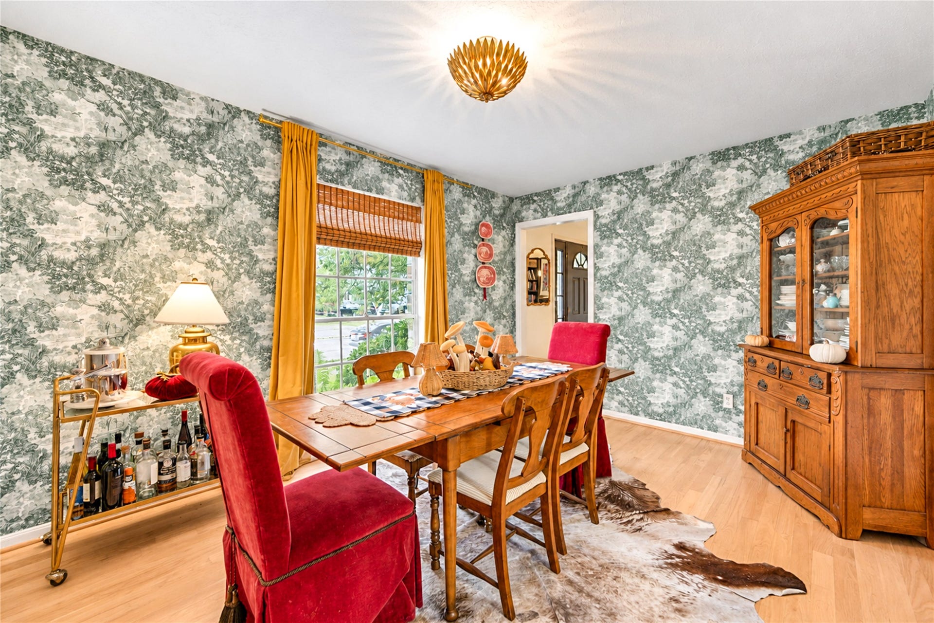 11423 Inwood Drive, Houston, TX 77077 Dinner parties never looked so inviting! This beautifully styled dining room makes a statement with its dramatic botanical wallpaper, rich wood floors and warm natural light. Thoughtfully curated by the home's interior decorator owner, this charming space blends timeless elegance with a touch of personality, creating the perfect backdrop for holiday celebrations, intimate dinners and memorable evenings with friends.