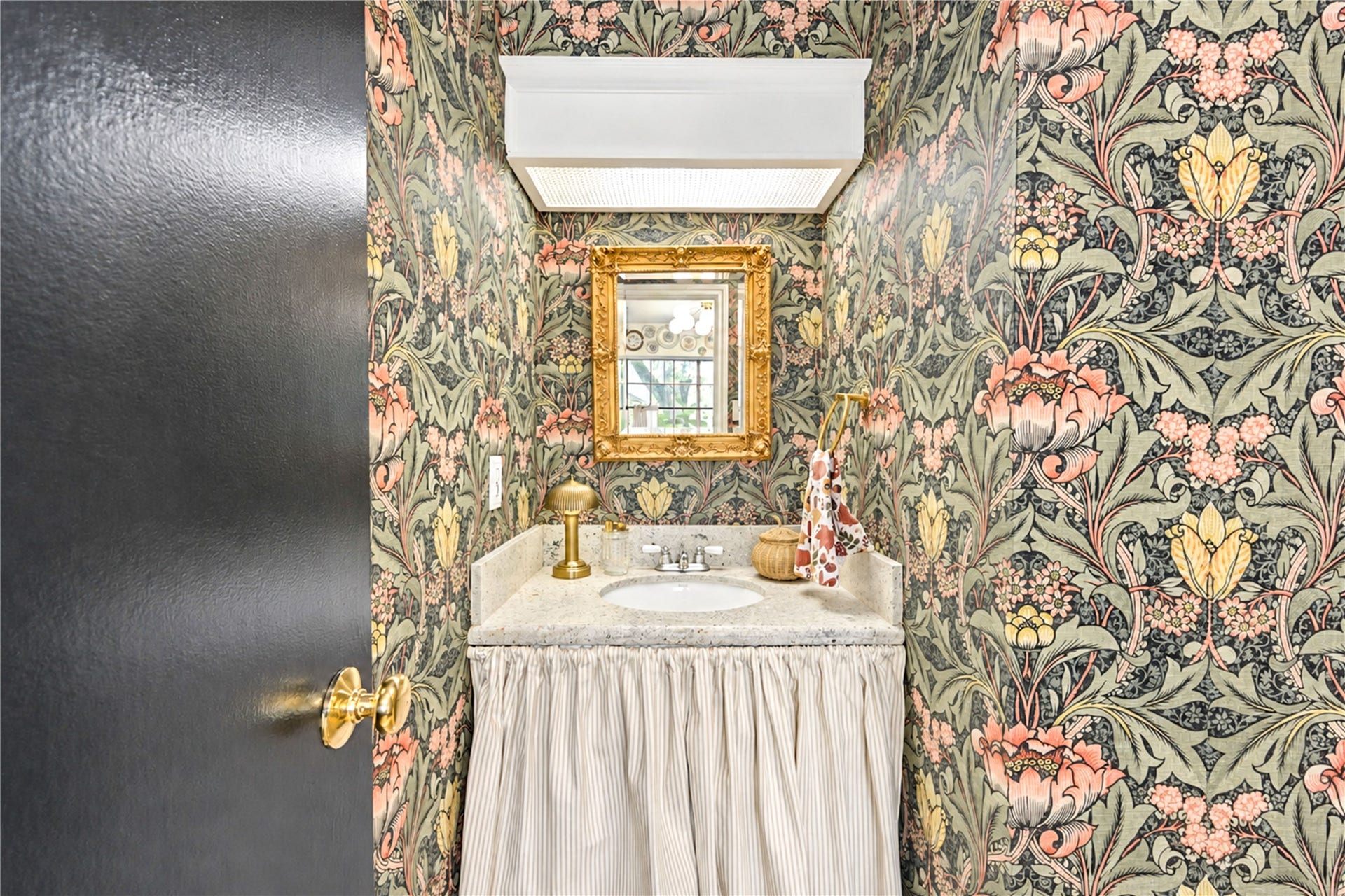 11423 Inwood Drive, Houston, TX 77077 A little jewel box of designer style! This charming first-floor powder room makes a bold statement with its gorgeous botanical wallpaper, elegant framed mirror and classic pedestal sink with a tailored fabric skirt. Thoughtfully styled by the home's interior decorator owner, this delightful space adds a touch of personality and sophistication, making even the smallest room feel special!