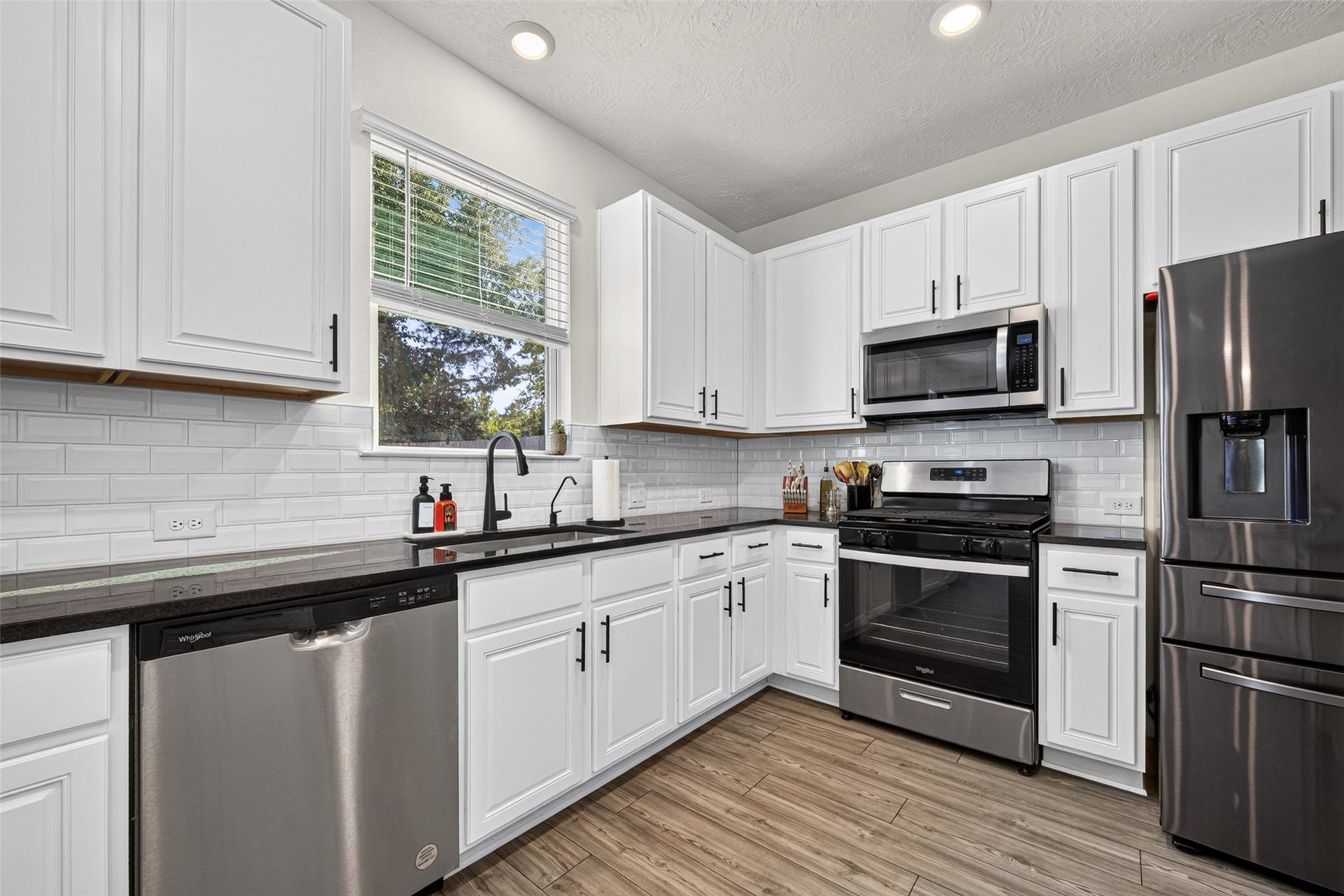 9453 Castillo Court, Magnolia, TX 77354 Natural light brightens this beautiful kitchen, highlighting the white cabinetry and stainless steel appliances. Imagine enjoying the convenience of a functional layout that makes everyday meal preparation effortless.