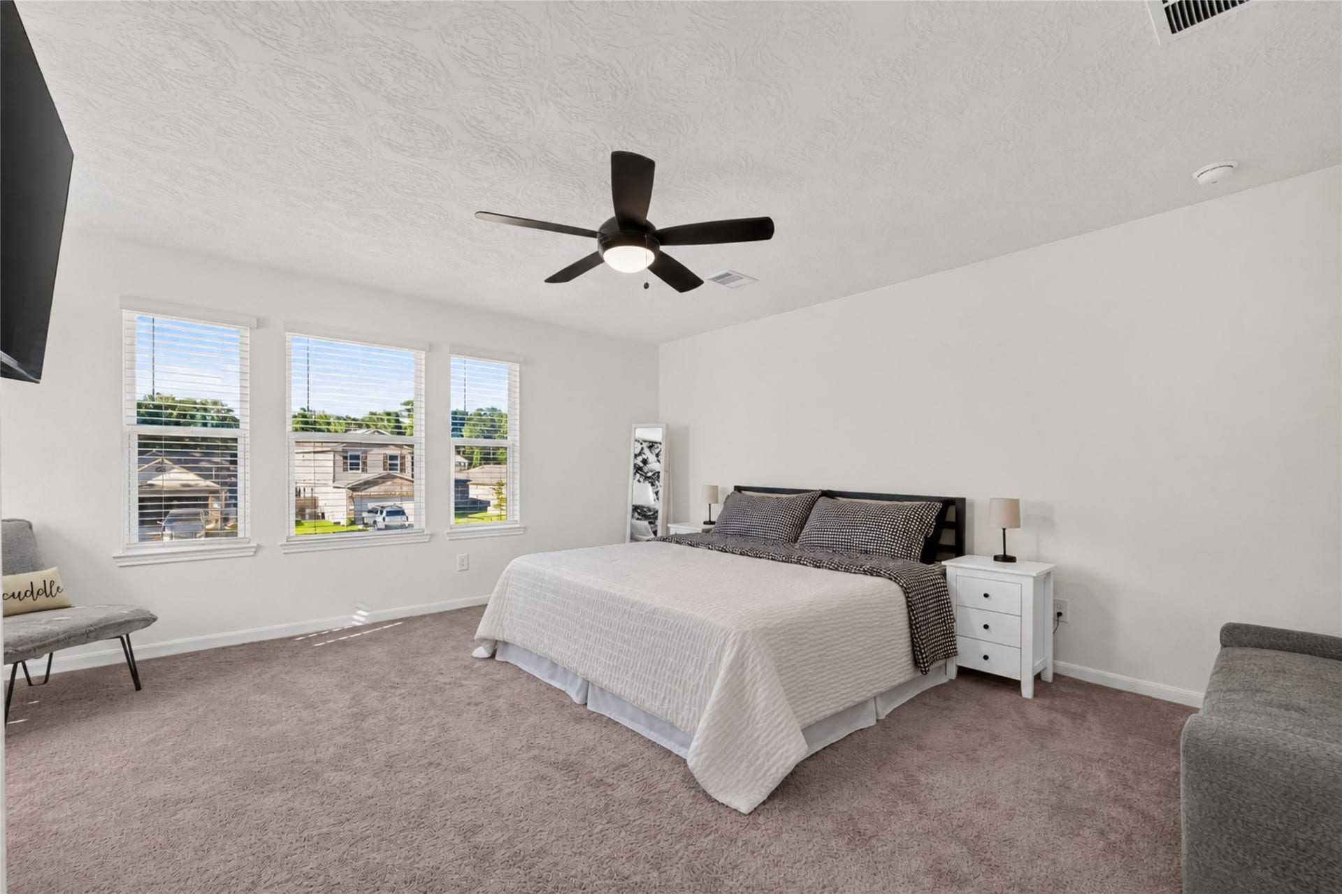 9453 Castillo Court, Magnolia, TX 77354 Retreat to this spacious primary bedroom featuring soft carpeting, a ceiling fan, and multiple windows that welcome natural light. The generous layout provides a comfortable setting for relaxation and restful evenings.