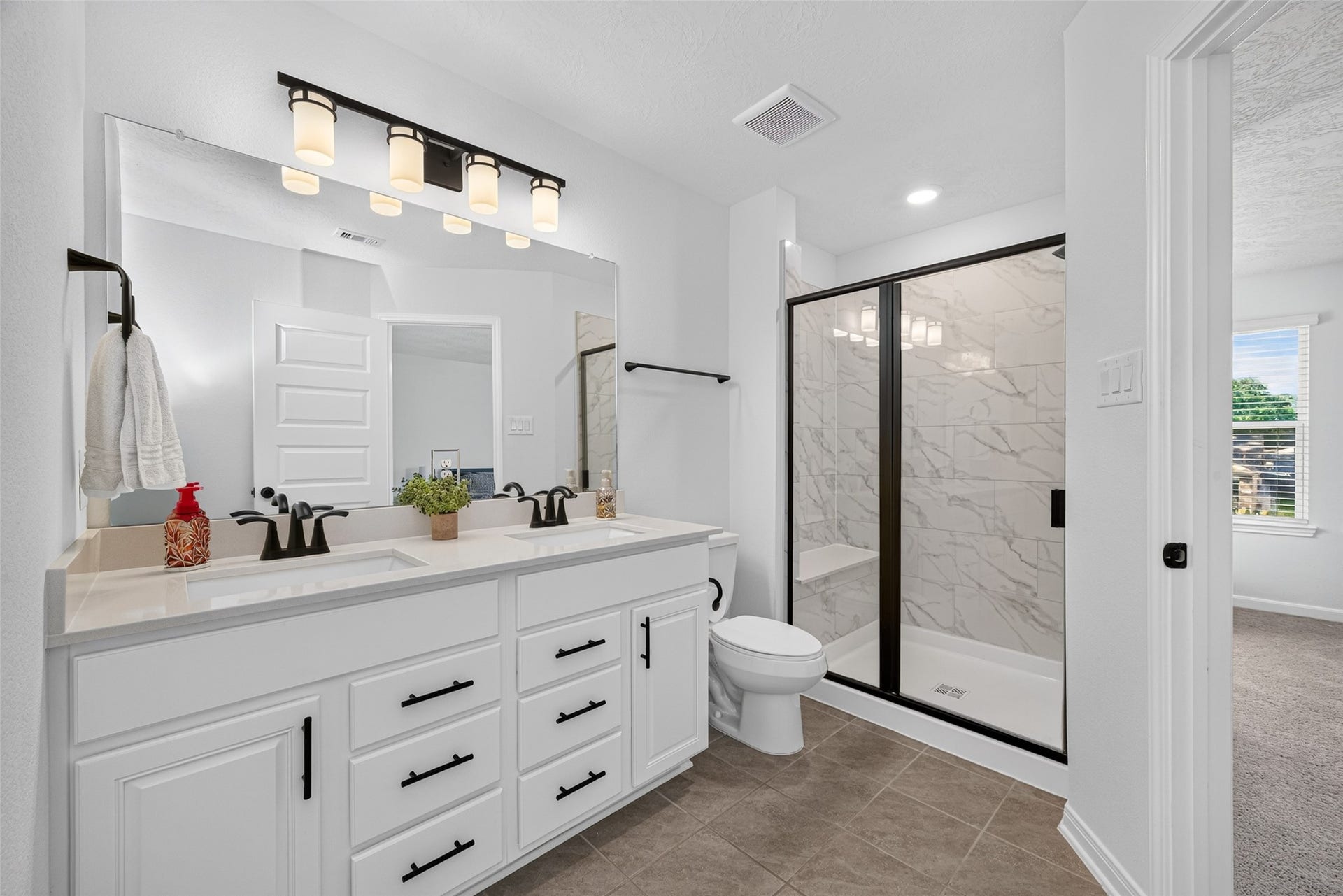 9453 Castillo Court, Magnolia, TX 77354 Enjoy the convenience of a private ensuite bathroom featuring an extended vanity and glass-enclosed shower. The spacious countertop and generous cabinetry make it easy to keep everyday essentials organized.