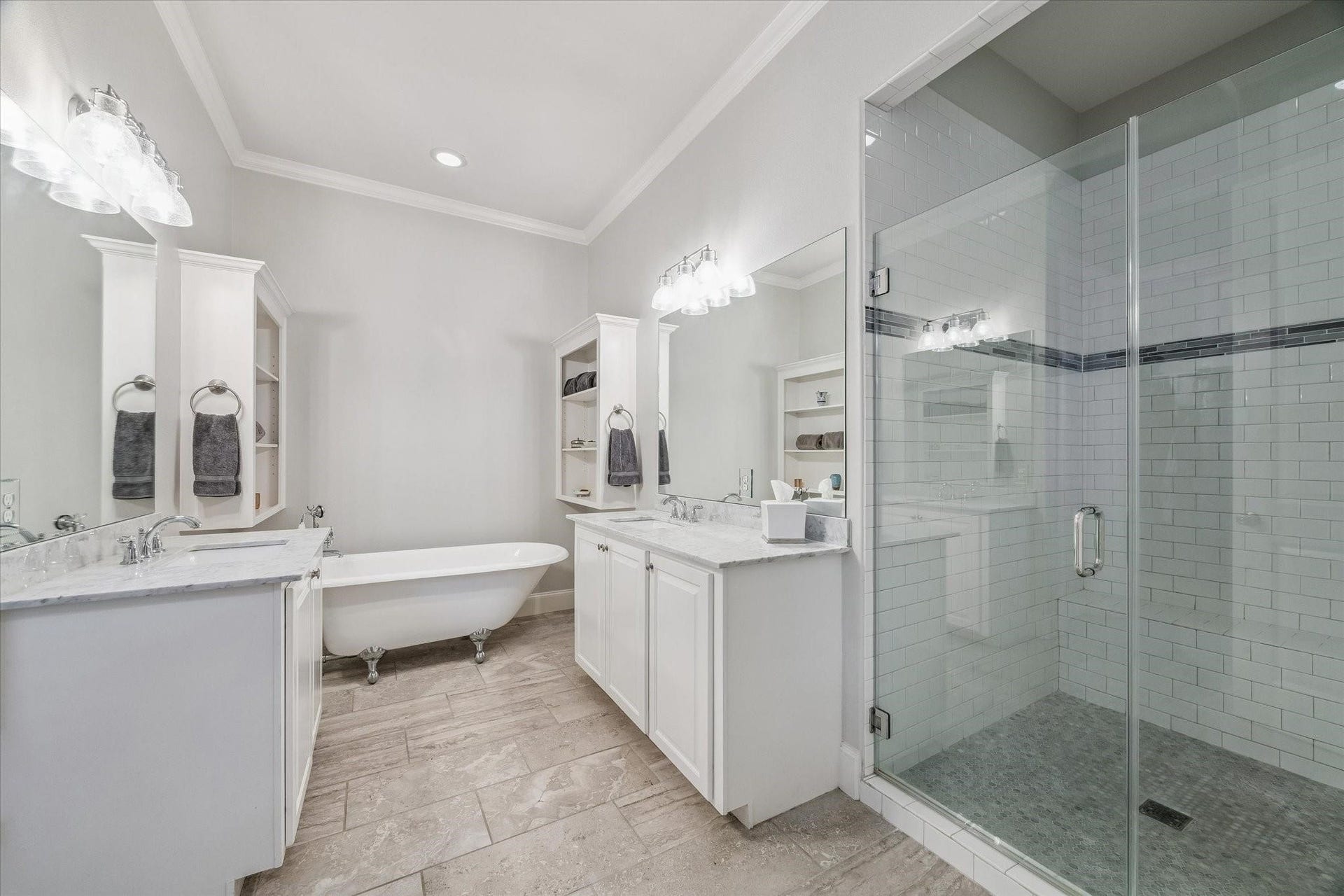 209 Queen Road, Clear Lake Shores, TX 77565 This bathroom features a clean and elegant design with a glass-enclosed walk-in shower, a classic clawfoot bathtub and dual vanities with ample counter space and storage