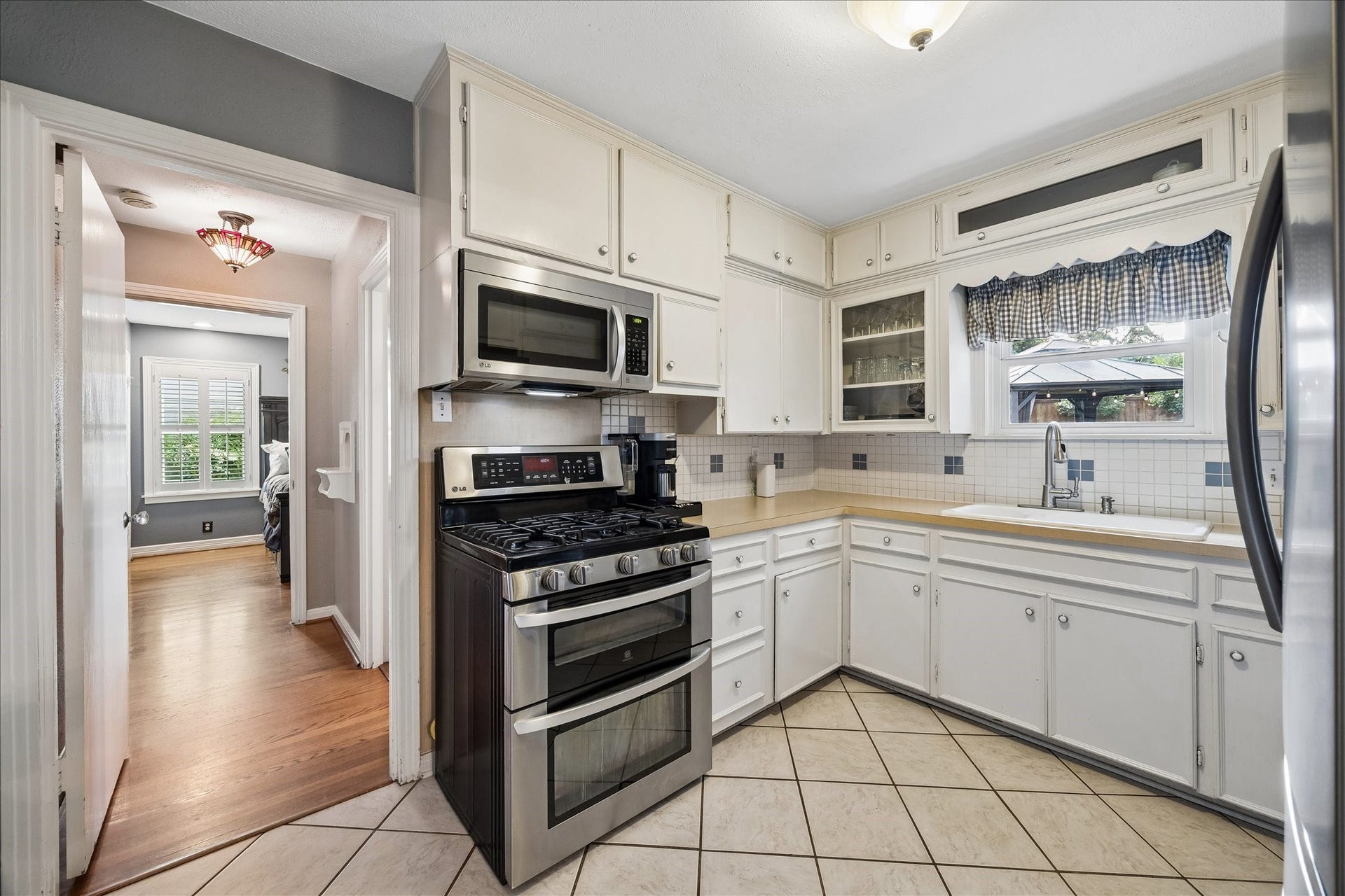 1611 Gardenia Drive, Houston, TX 77018 Compact and efficient, the kitchen makes smart use of its footprint with cabinetry extending to the ceiling and generous counter space wrapping around three sides. Stainless steel appliances and a gas range round out the space.