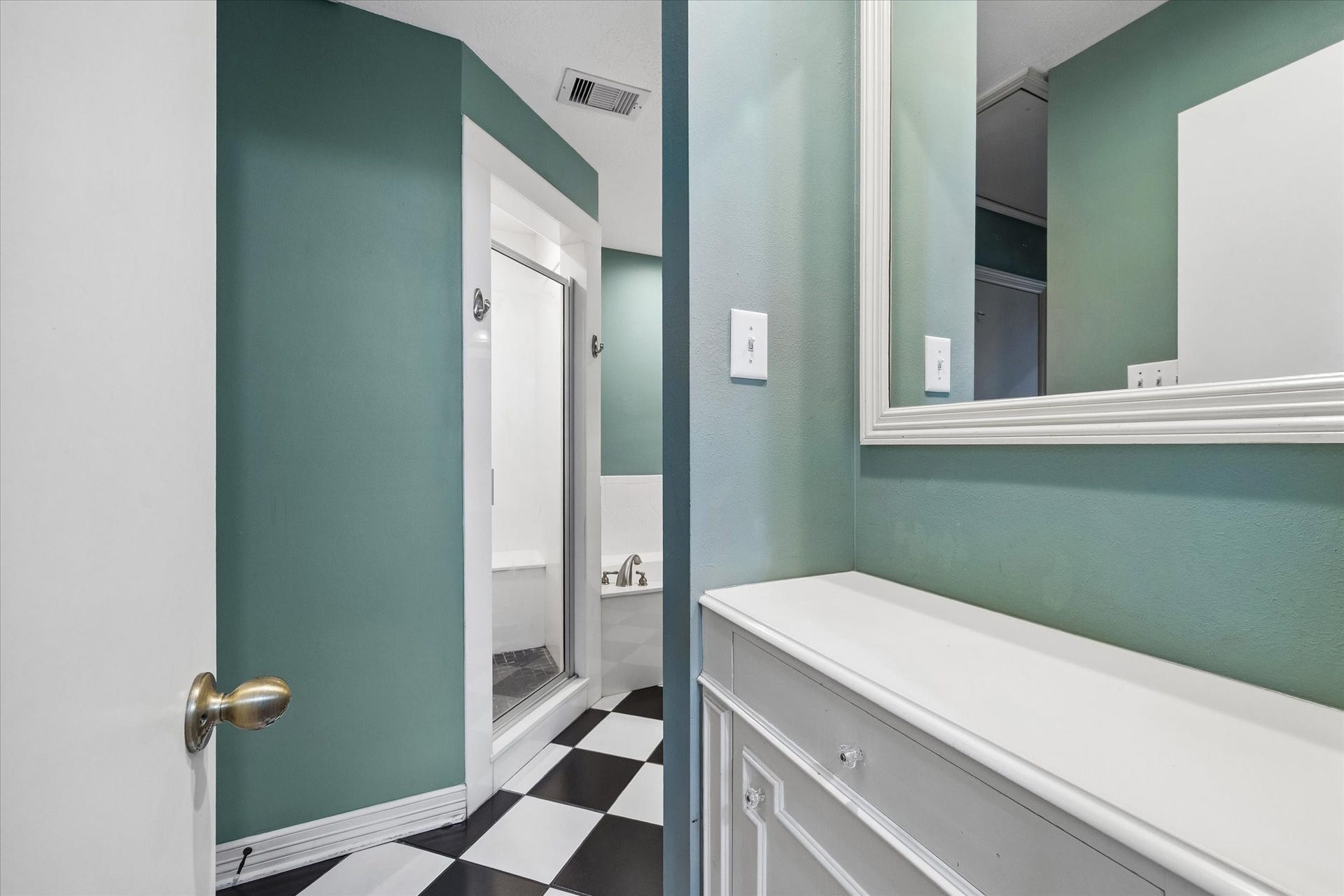 1611 Gardenia Drive, Houston, TX 77018 The primary ensuite entry creates a defined transition into the primary bath, with built in cabinetry providing convenient storage before opening to the tub, shower and vanity areas.