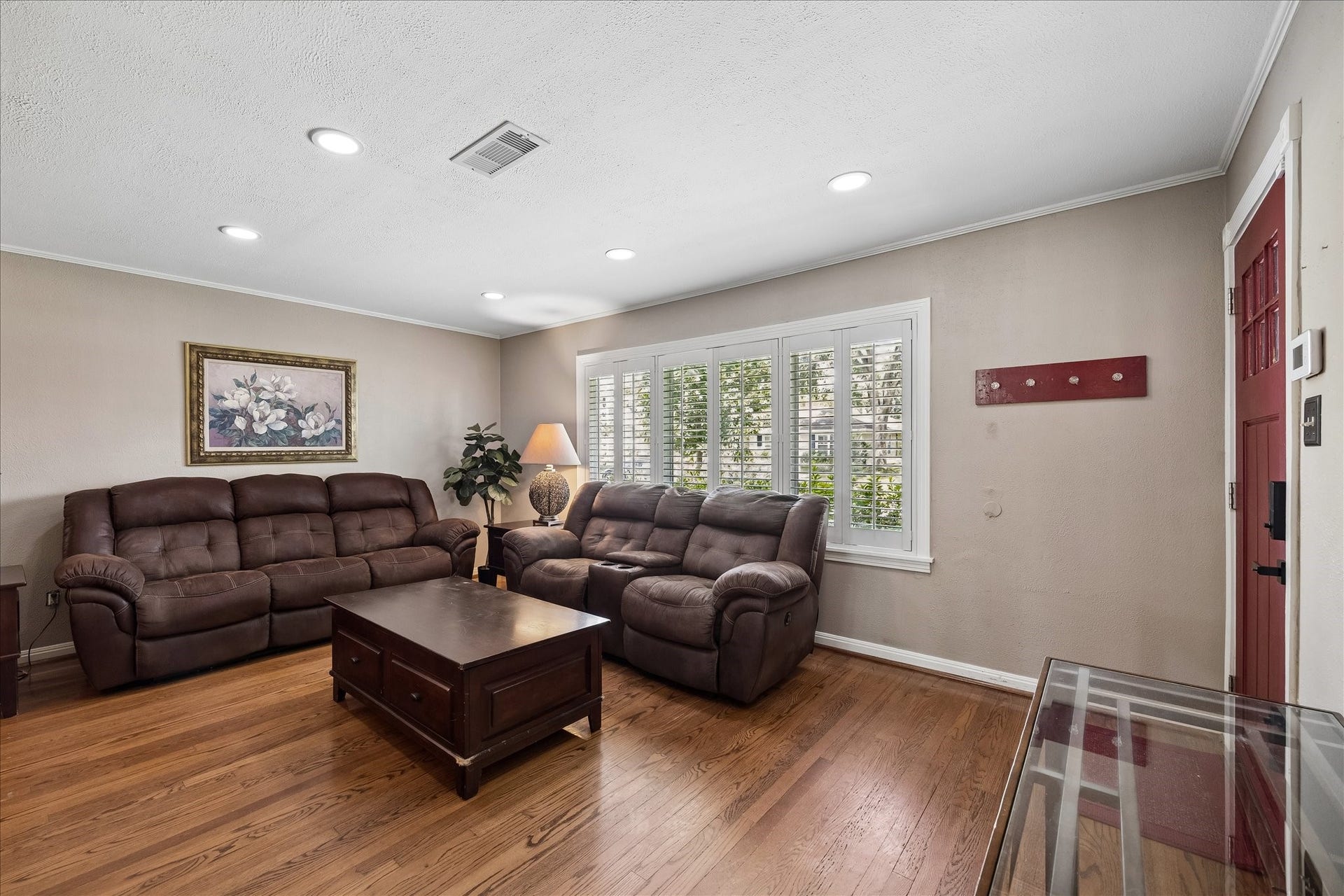 1611 Gardenia Drive, Houston, TX 77018 Warm hardwood floors carry through the living room, while plantation shutters filter natural light from the large front window. Recessed lighting and a neutral palette keep the space bright and comfortable for everyday living.