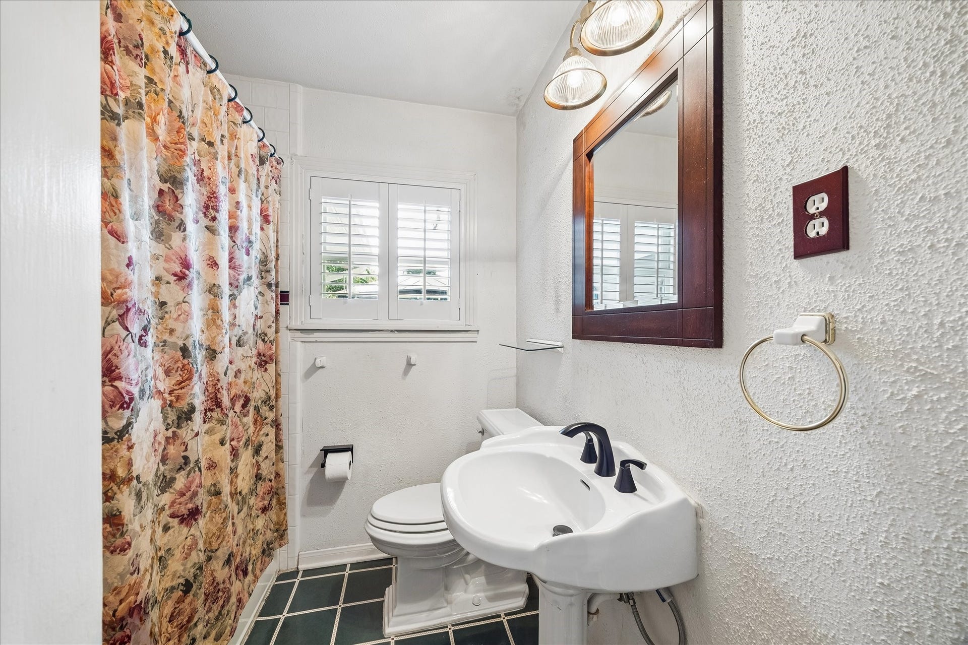 1611 Gardenia Drive, Houston, TX 77018 Hall bath features a tub and shower combination, pedestal sink and plantation shuttered window that brings natural light into the space while maintaining privacy.