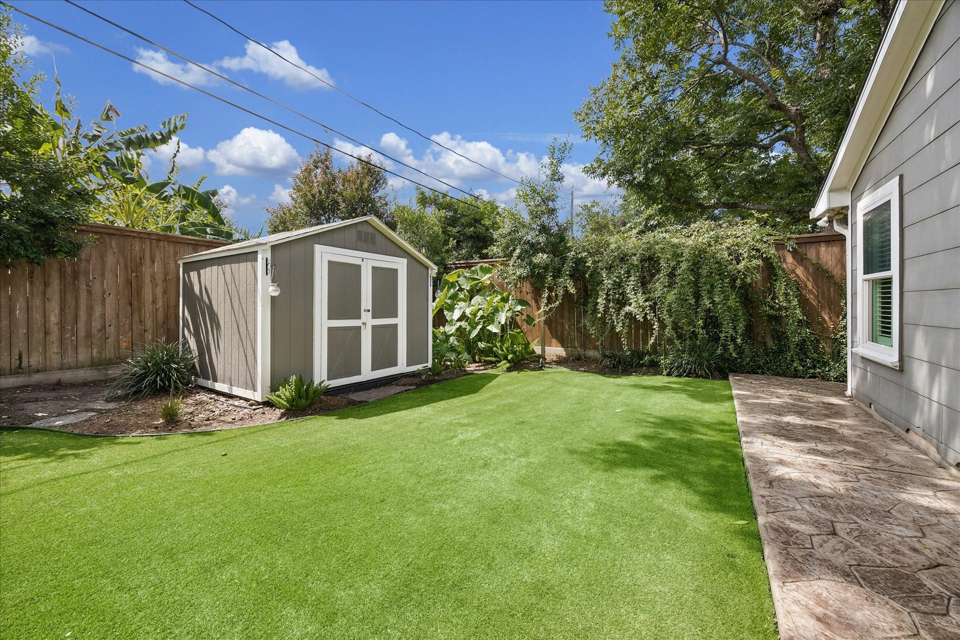 1611 Gardenia Drive, Houston, TX 77018 A storage shed is thoughtfully positioned along the perimeter, leaving the surrounding turfed lawn open and uncluttered.