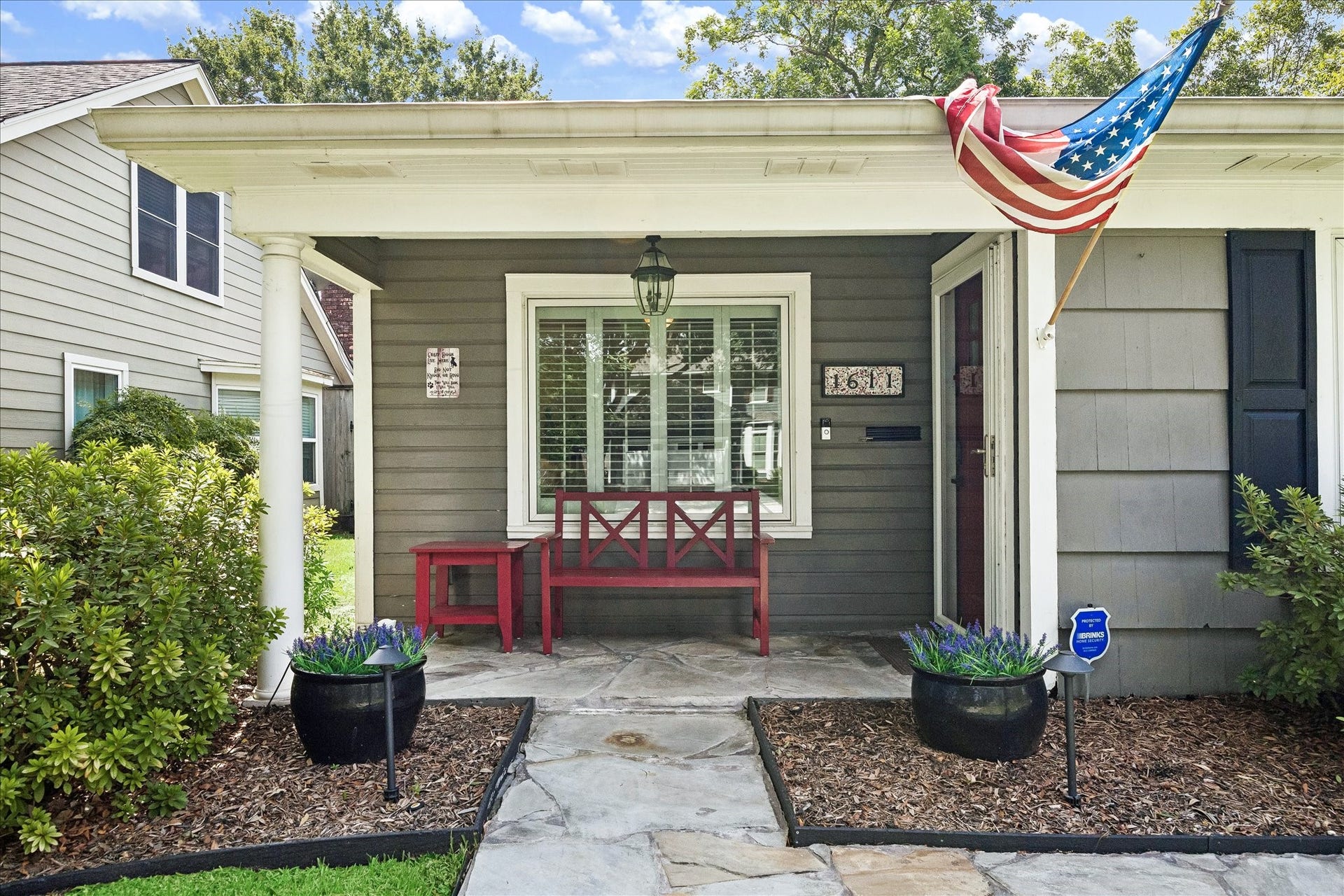 1611 Gardenia Drive, Houston, TX 77018 A covered front porch creates a welcoming arrival, framed by mature landscaping and classic architectural details. The shaded setting offers a comfortable spot to enjoy the charm of the Oak Forest neighborhood.