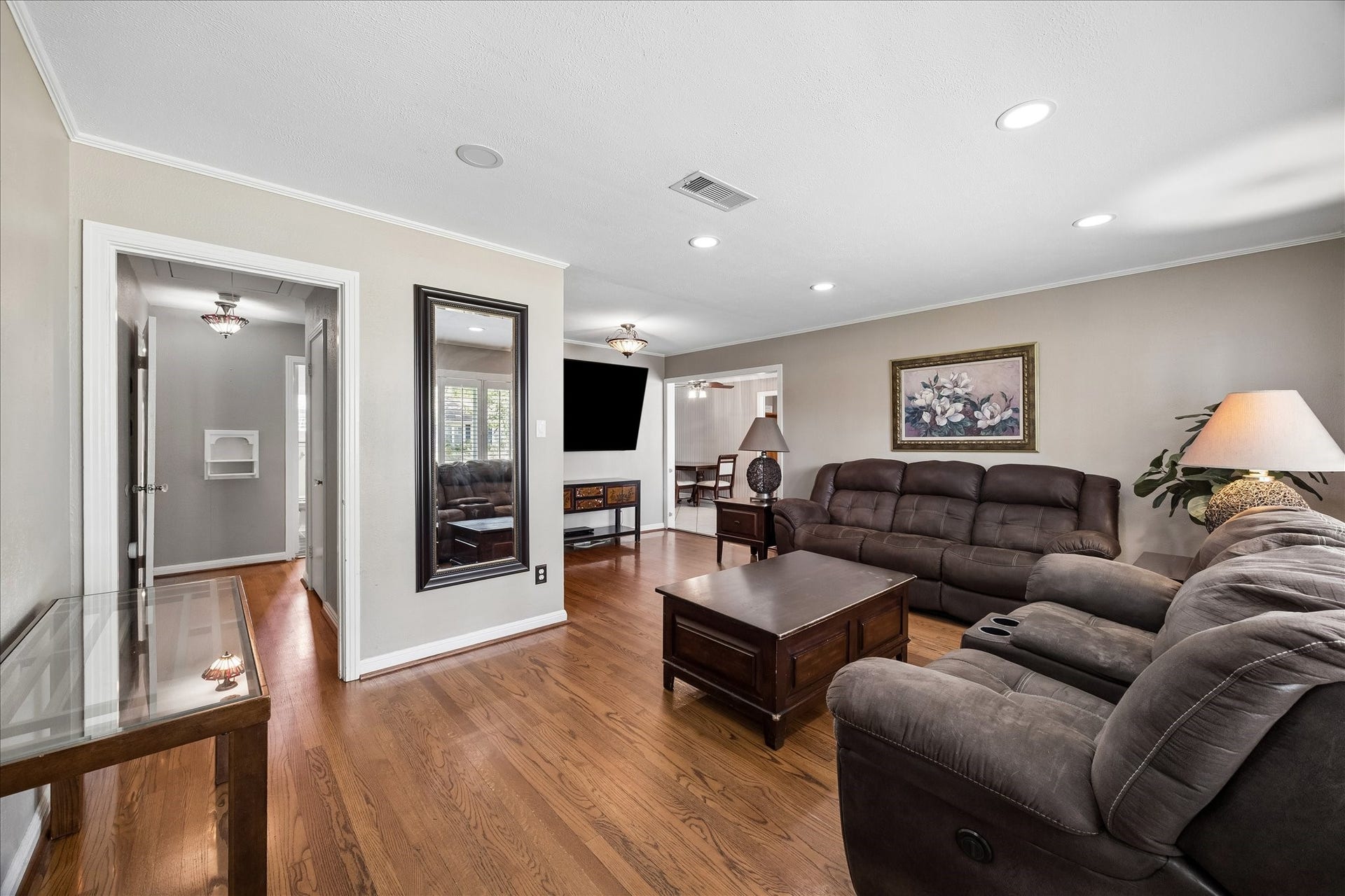 1611 Gardenia Drive, Houston, TX 77018 From the entry, the home opens into a spacious living area with warm hardwood floors and clear sightlines into the adjoining dining space. The connected layout creates an easy flow while each room maintains its own defined purpose.