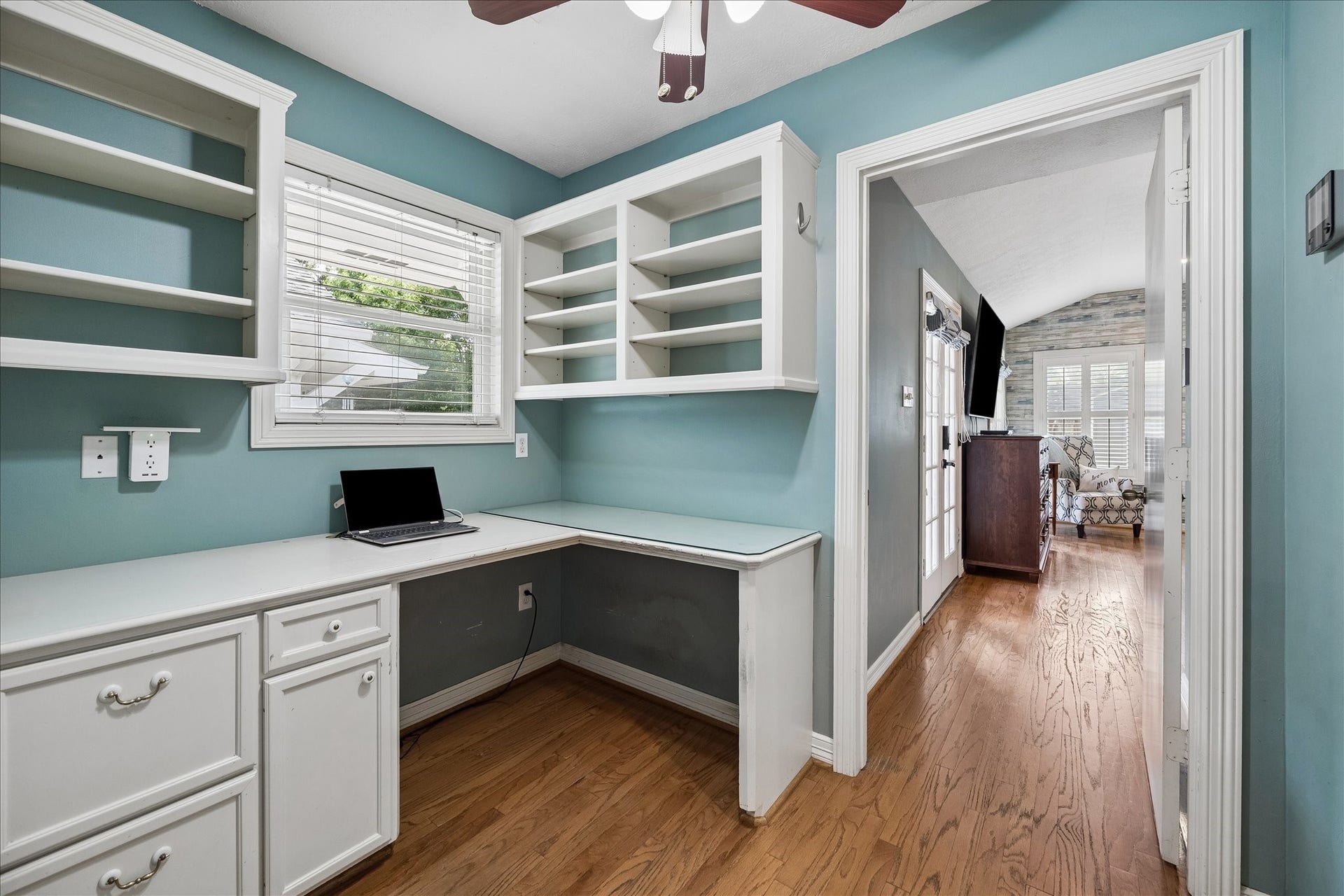 1611 Gardenia Drive, Houston, TX 77018 Tucked just outside the primary bedroom, this dedicated workspace features built in cabinetry, open shelving and a wraparound desk with natural light. A smart use of space for a private home office or study nook.