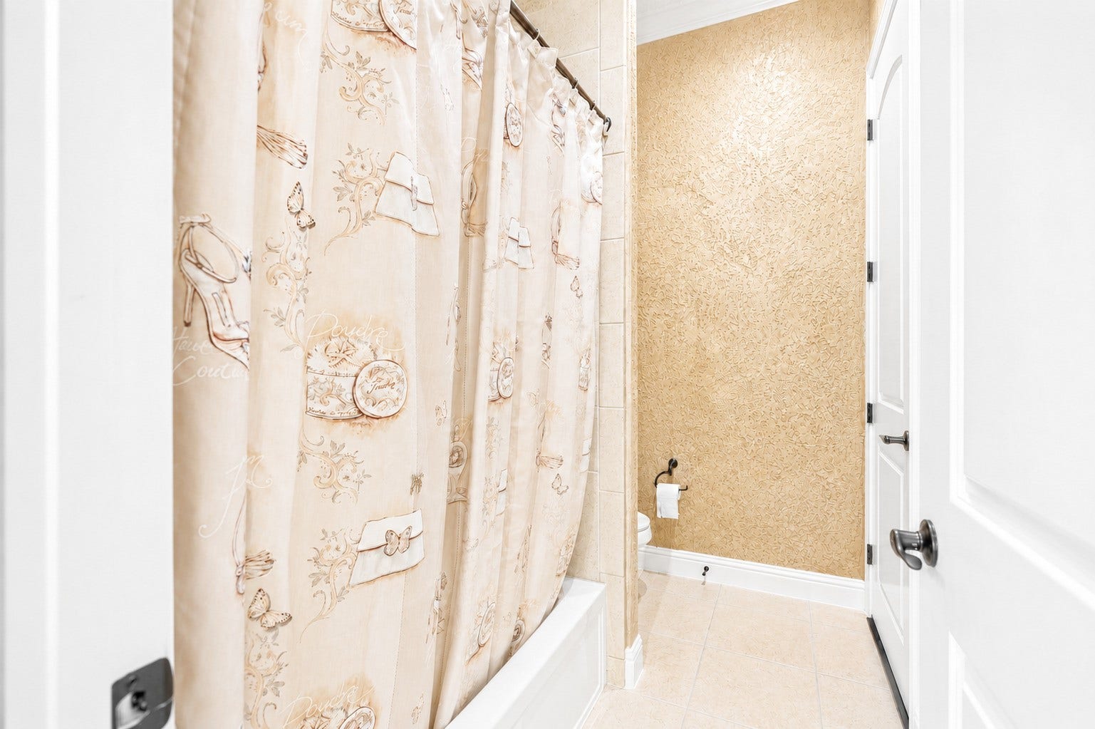 Another view of the bathroom highlighting the tub and shower area with tile flooring and convenient access to the vanity.